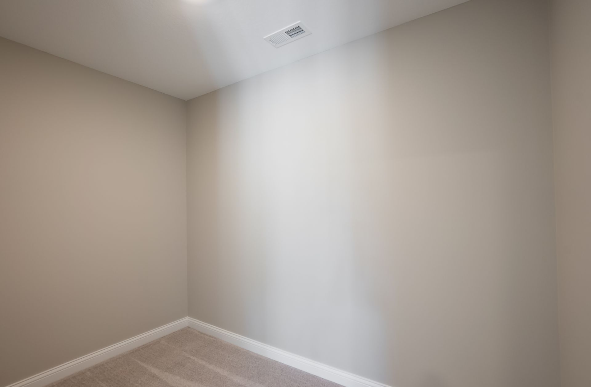 An empty room with white walls and a ceiling fan.