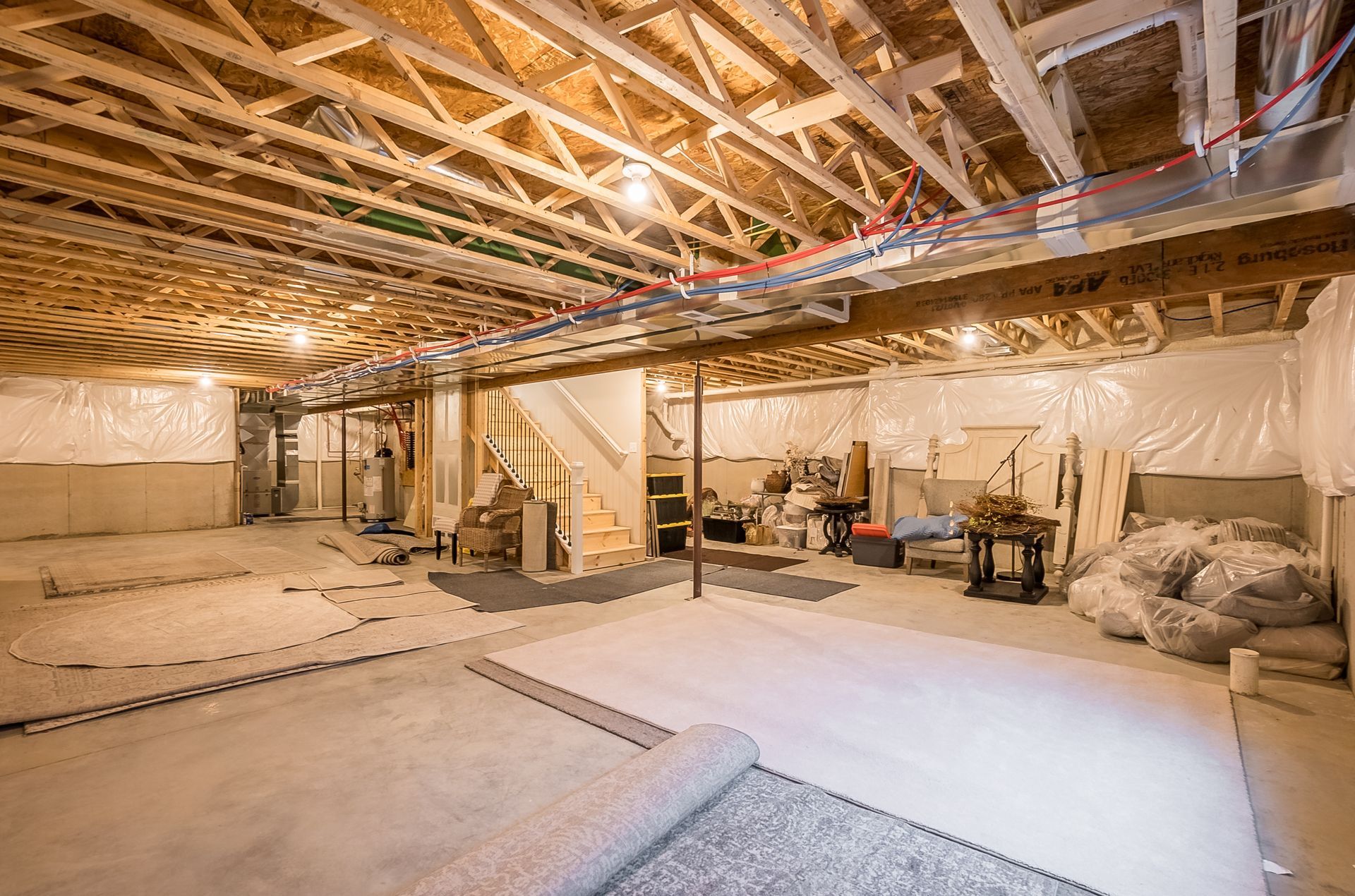 A basement under construction with a carpet on the floor.