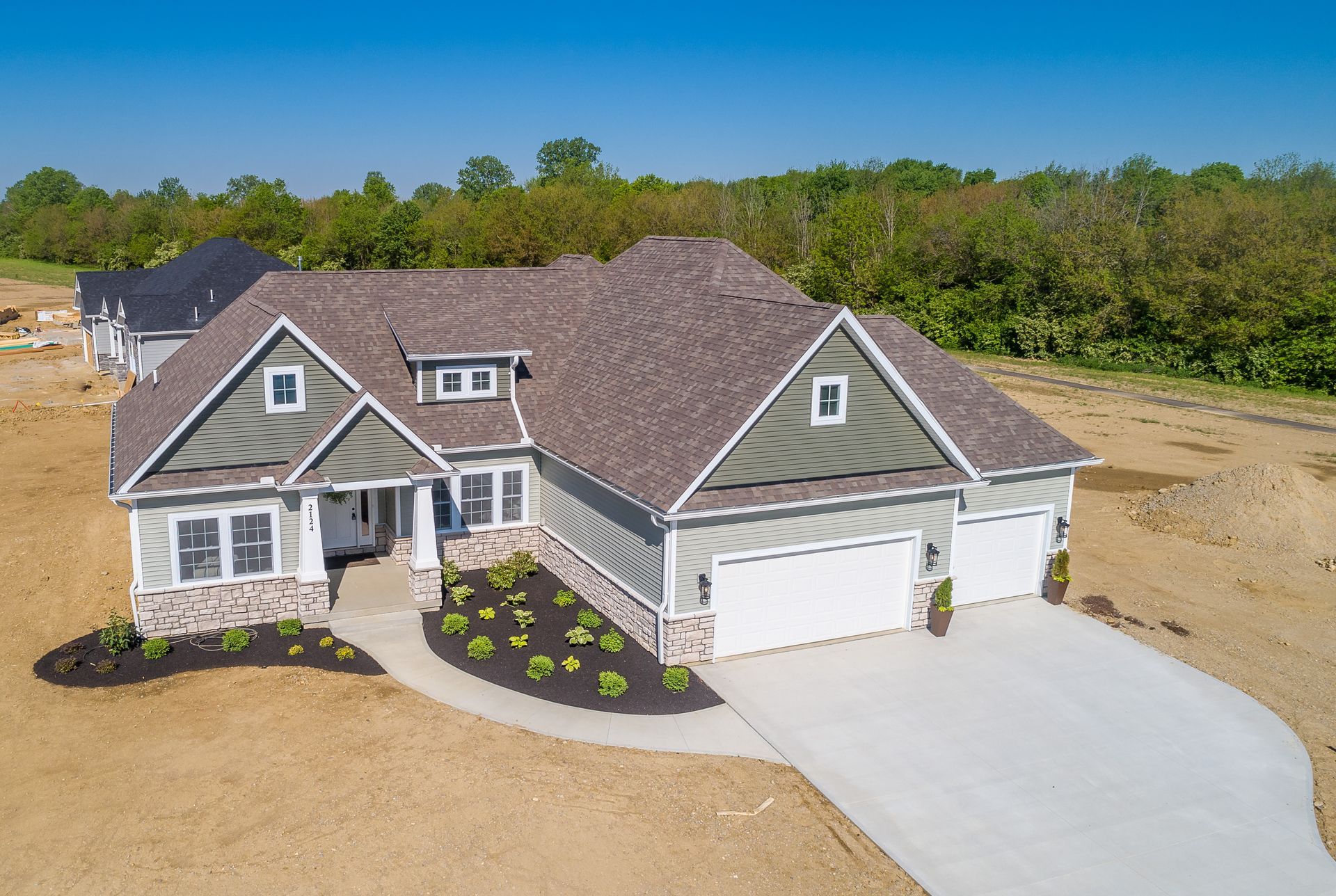 An aerial view of a large house with two garages and a driveway.