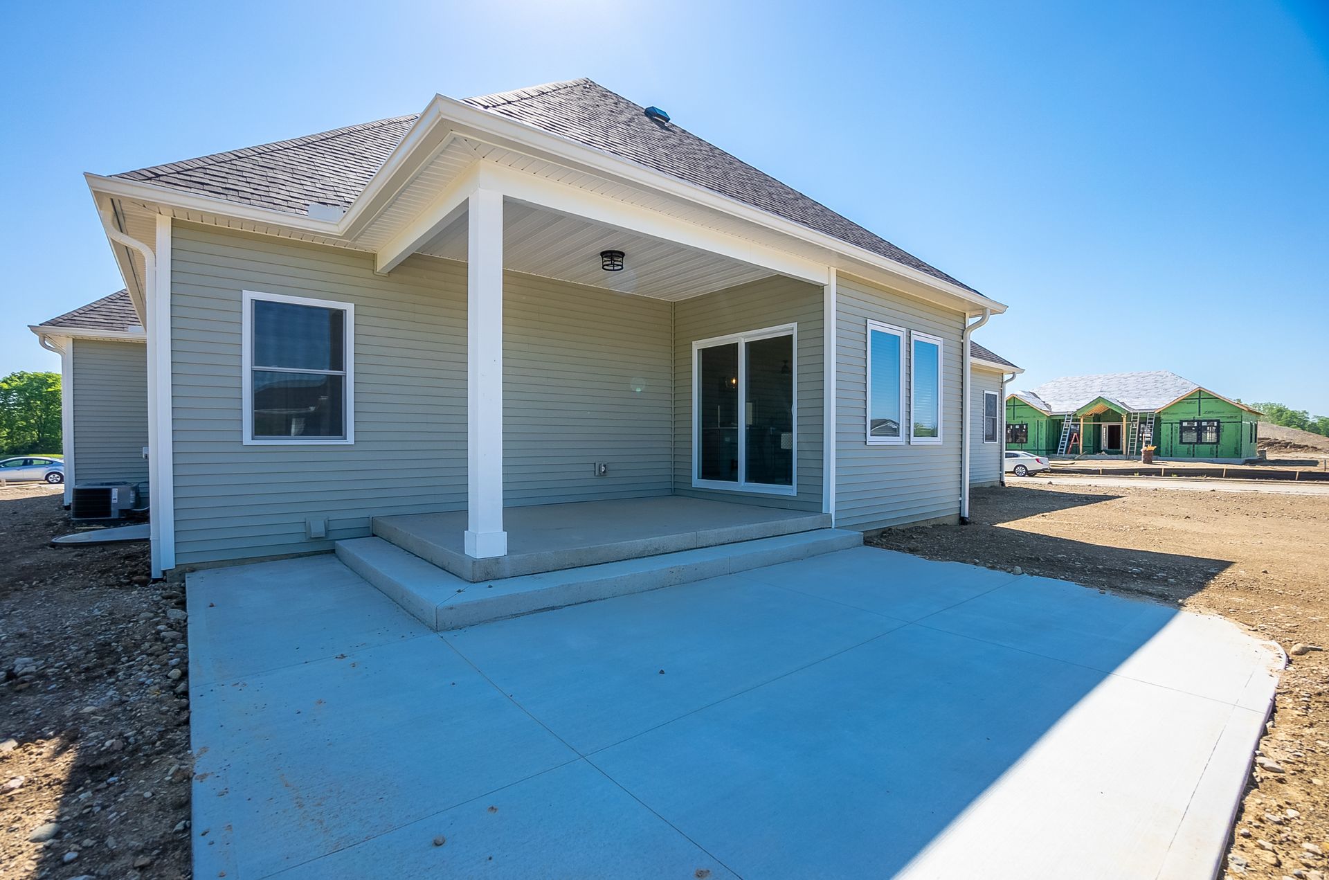 The back of a house with a porch and sliding glass doors.