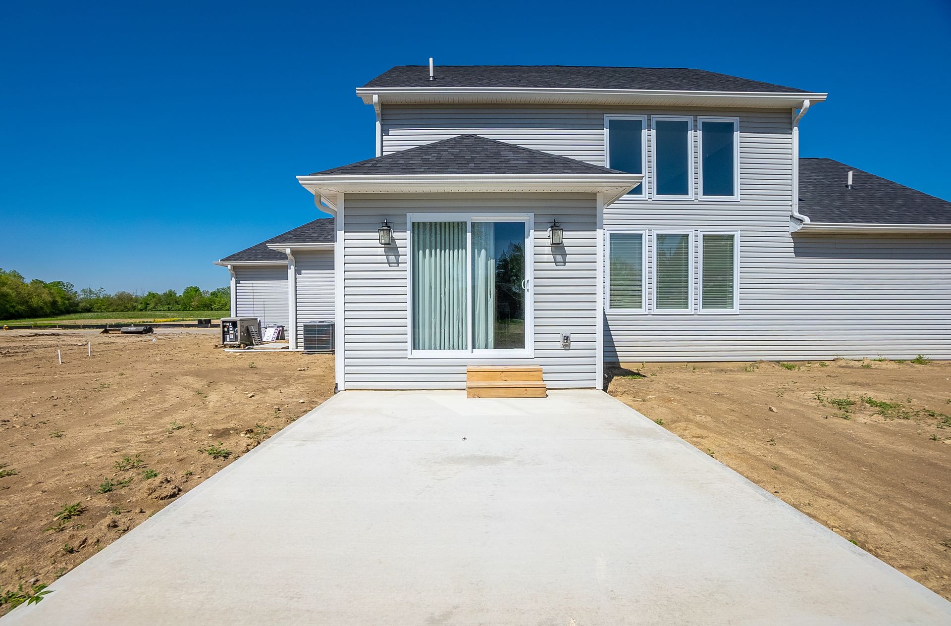 A white house with a concrete driveway leading to it