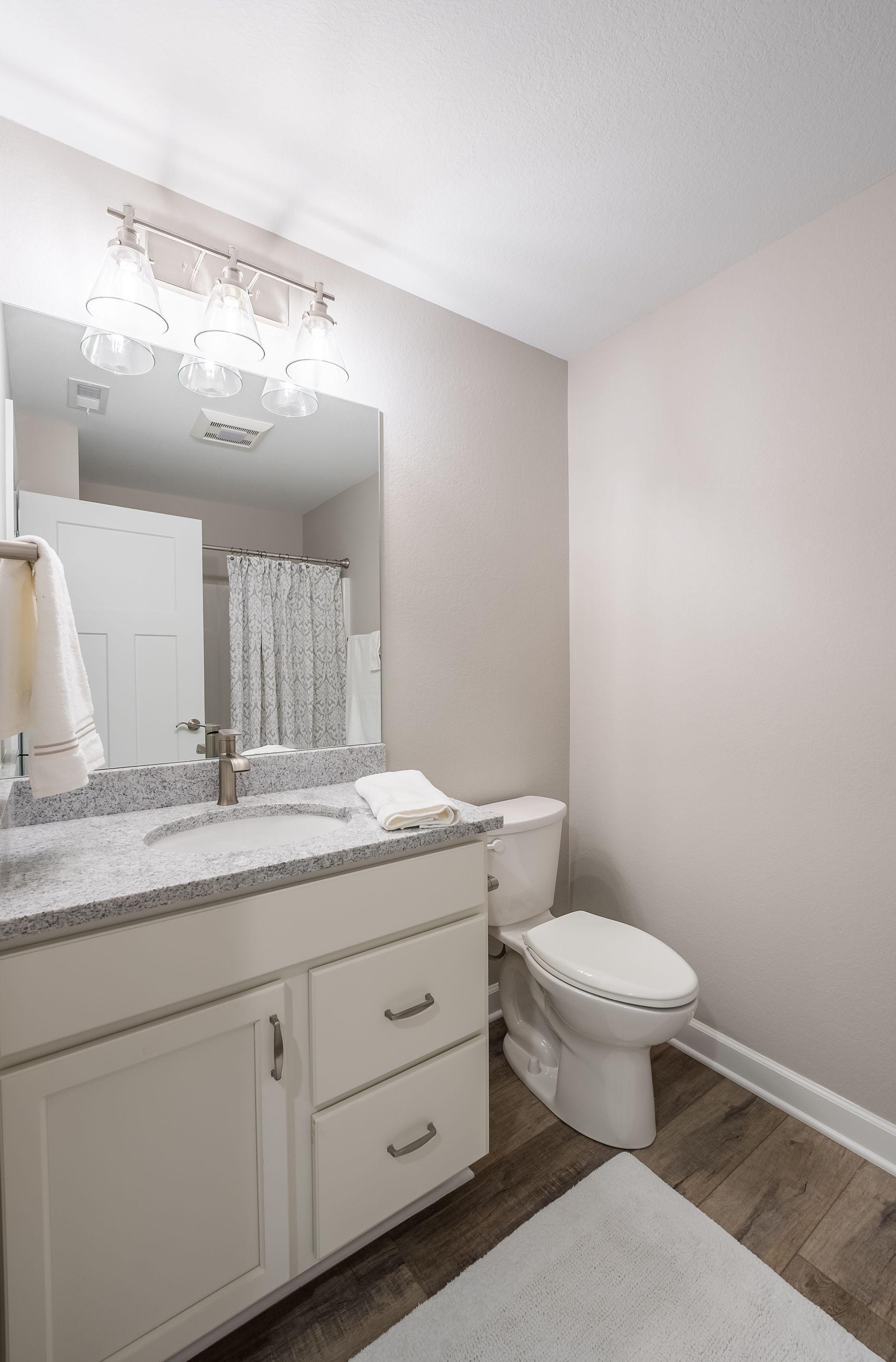 A bathroom with a sink , toilet , and mirror.