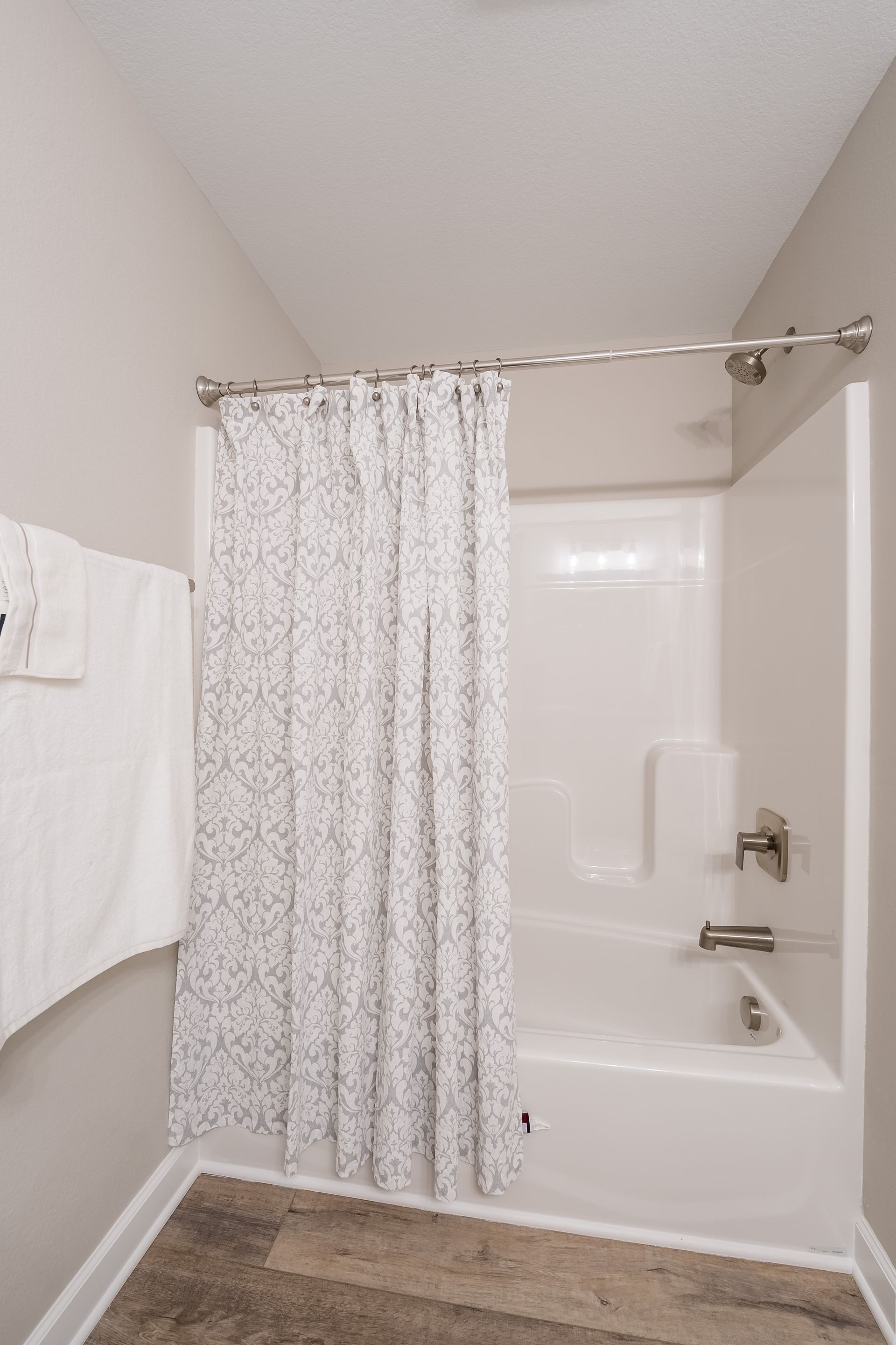 A bathroom with a shower curtain and a bathtub.