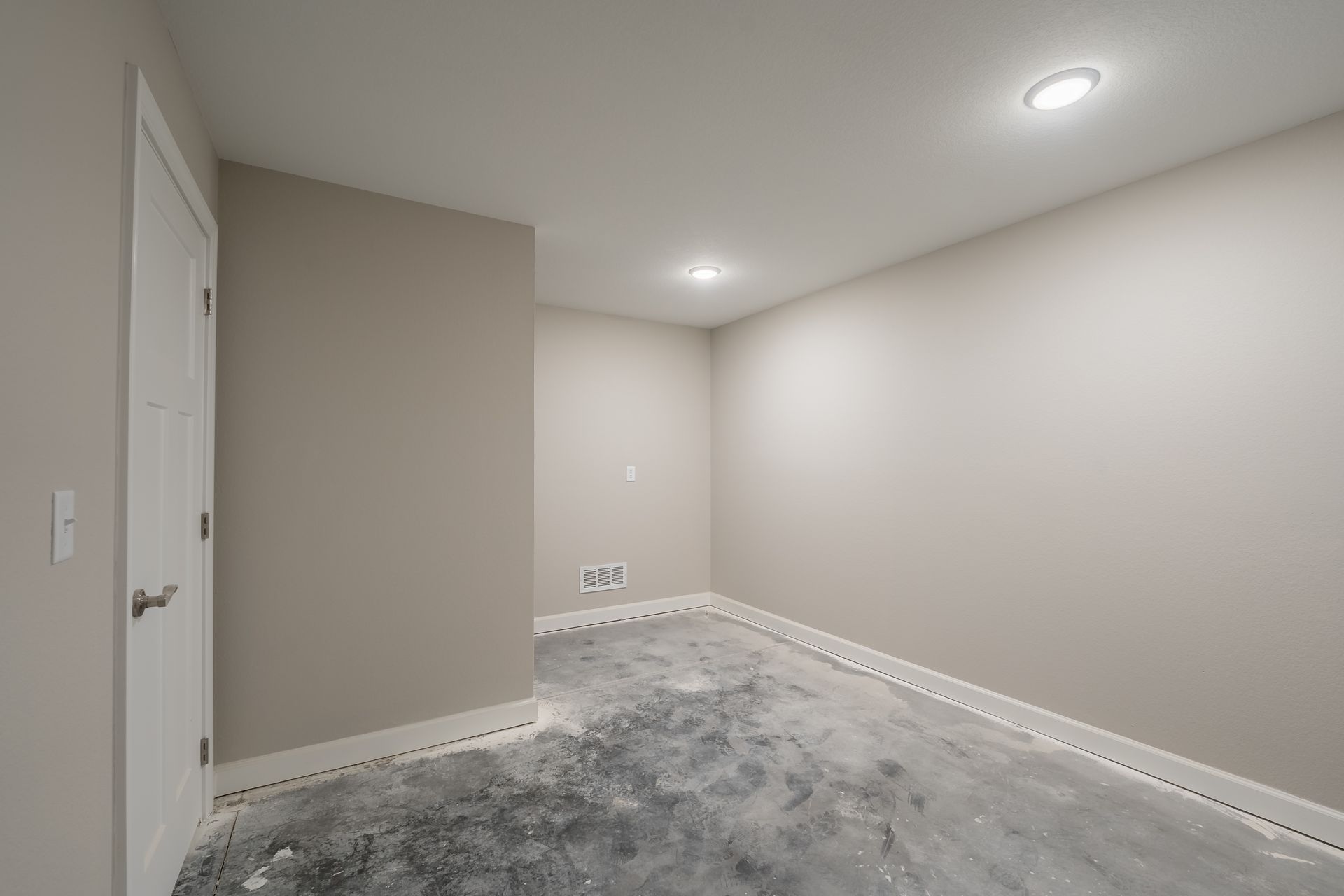 An empty room with a flooded floor and a door.