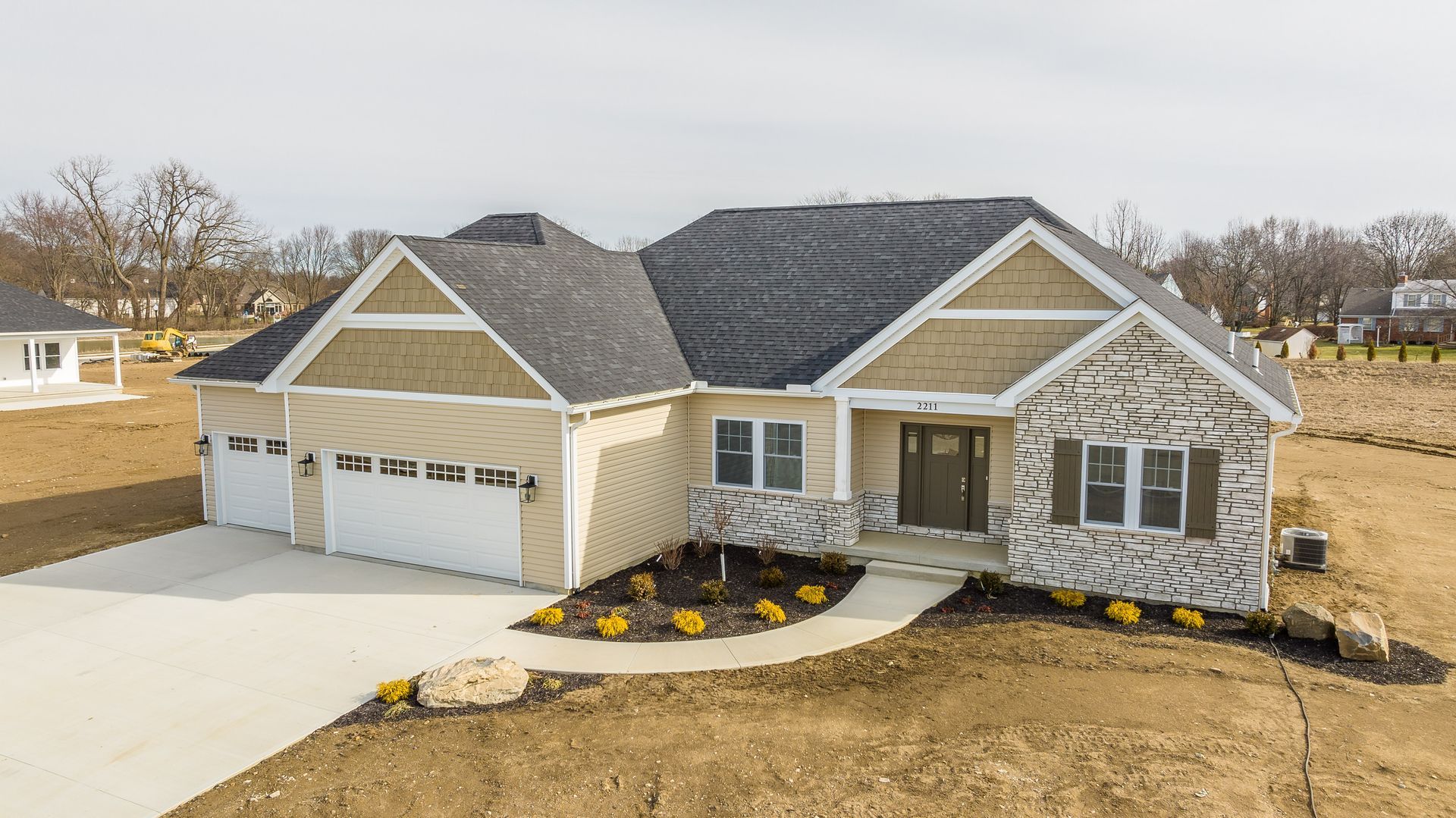An aerial view of a house with a large driveway.