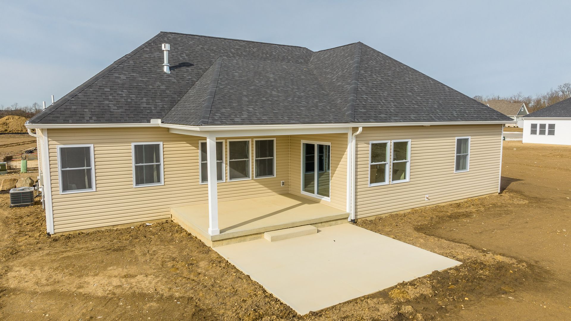 An aerial view of a house under construction in a dirt field.
