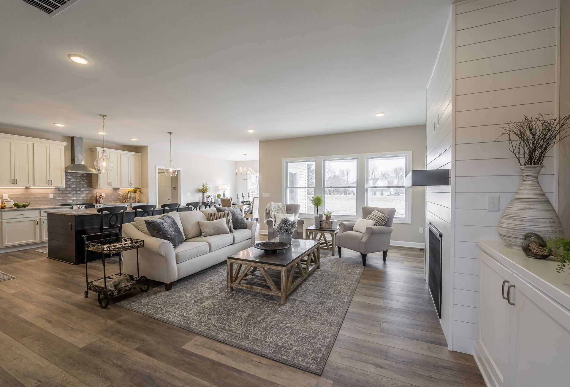 A living room with a couch , chairs , coffee table and fireplace.