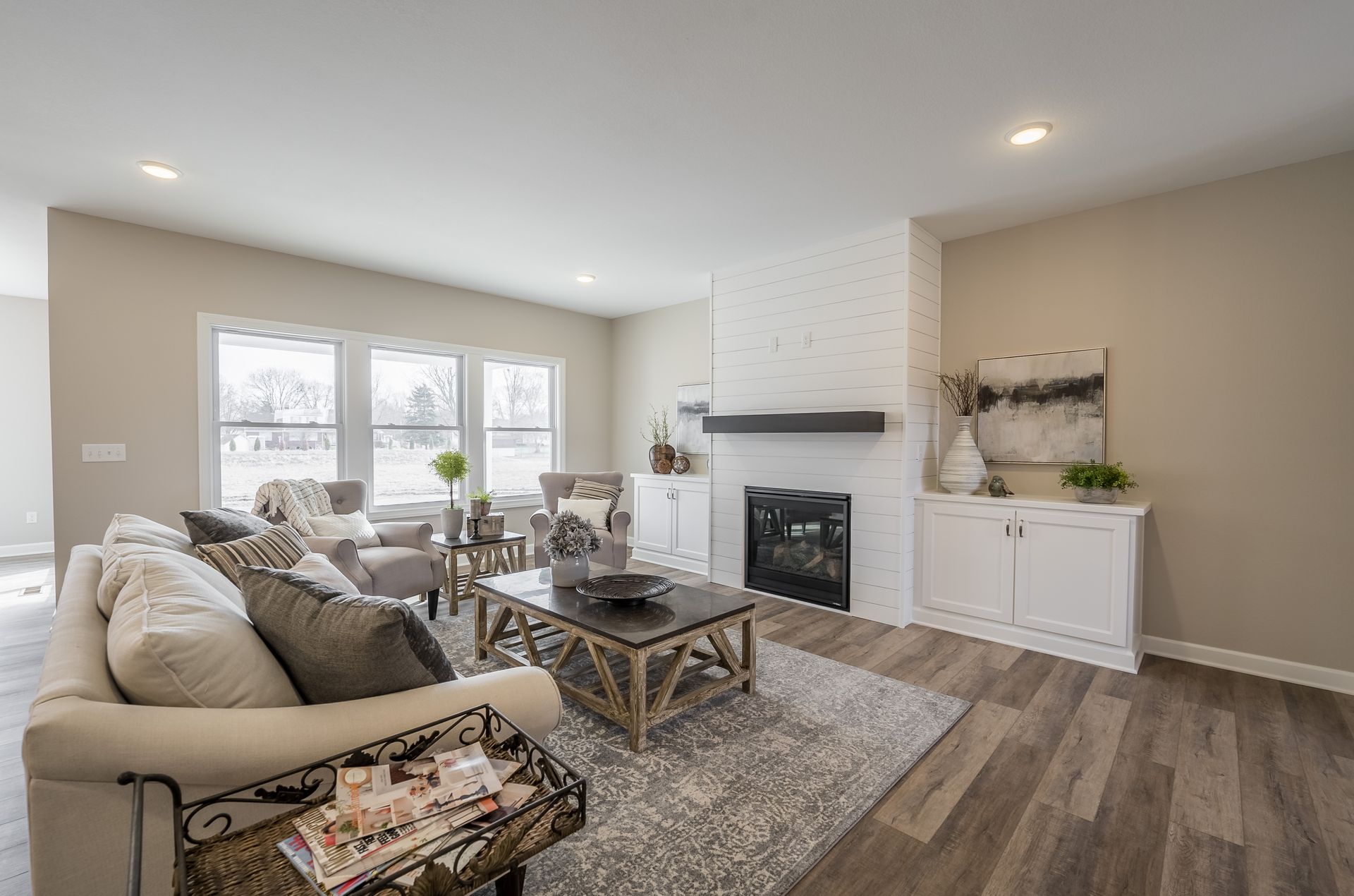 A living room with a couch , chairs , coffee table and fireplace.