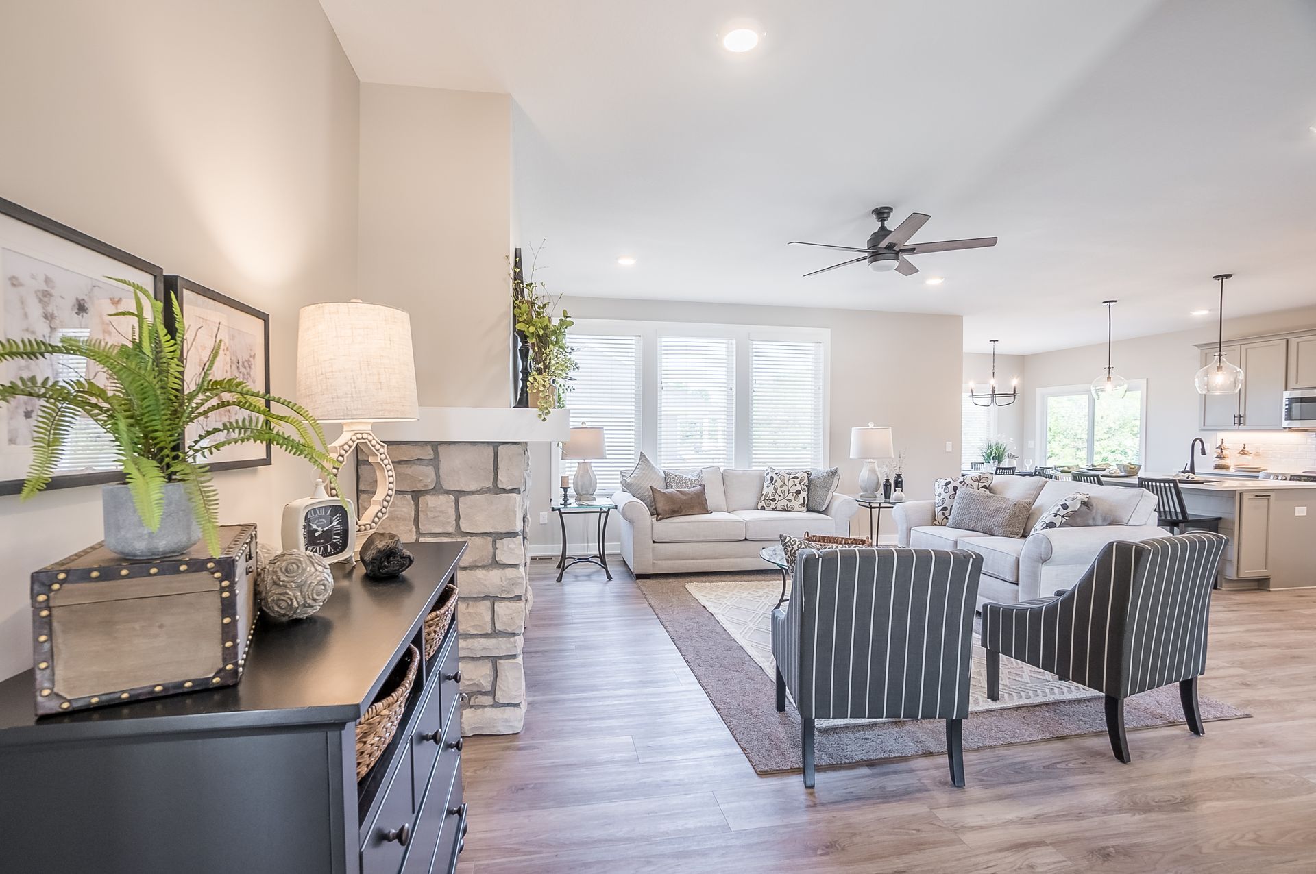 A living room with a couch , chairs , and a ceiling fan.
