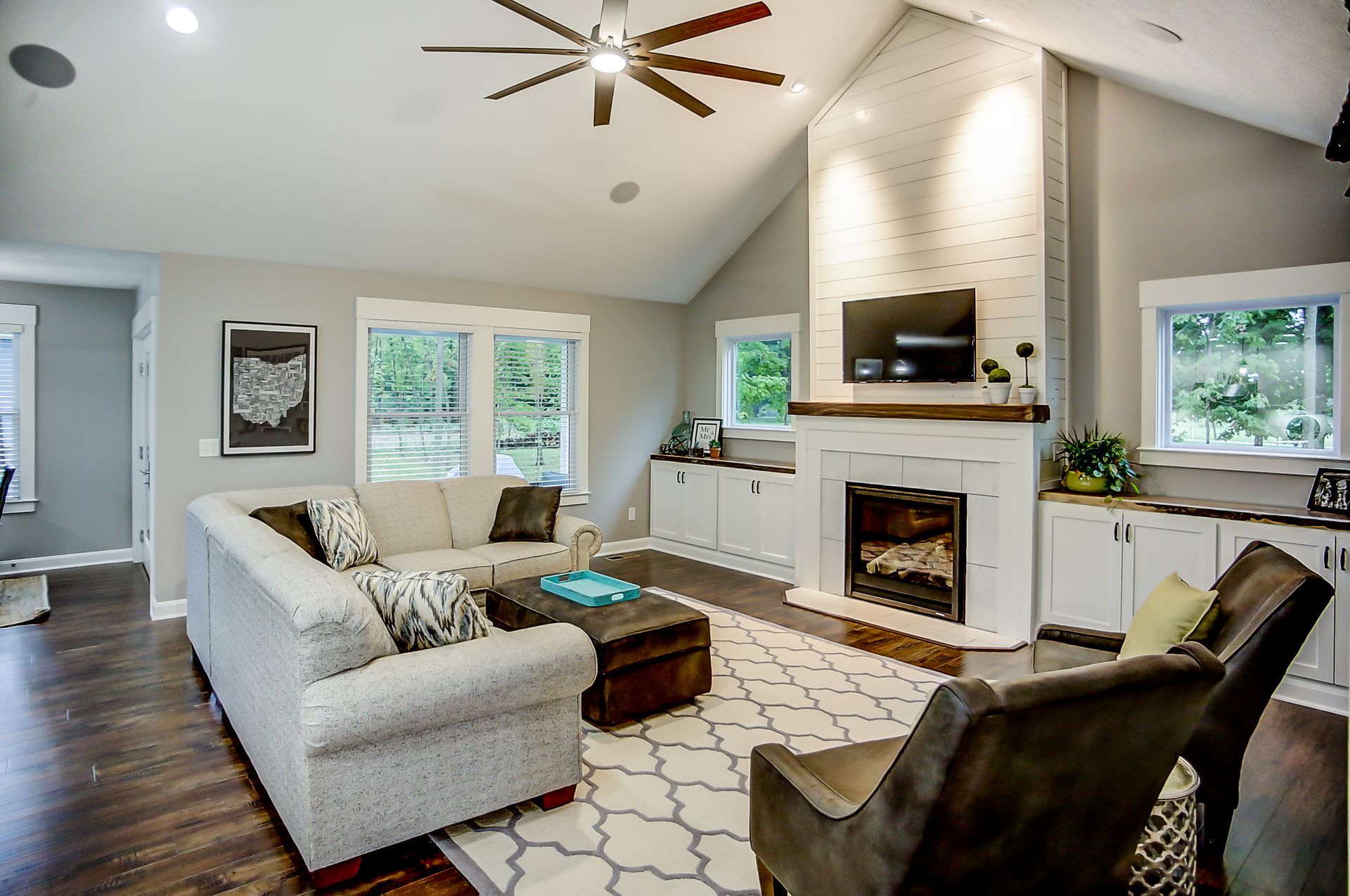 A living room with a fireplace and a ceiling fan