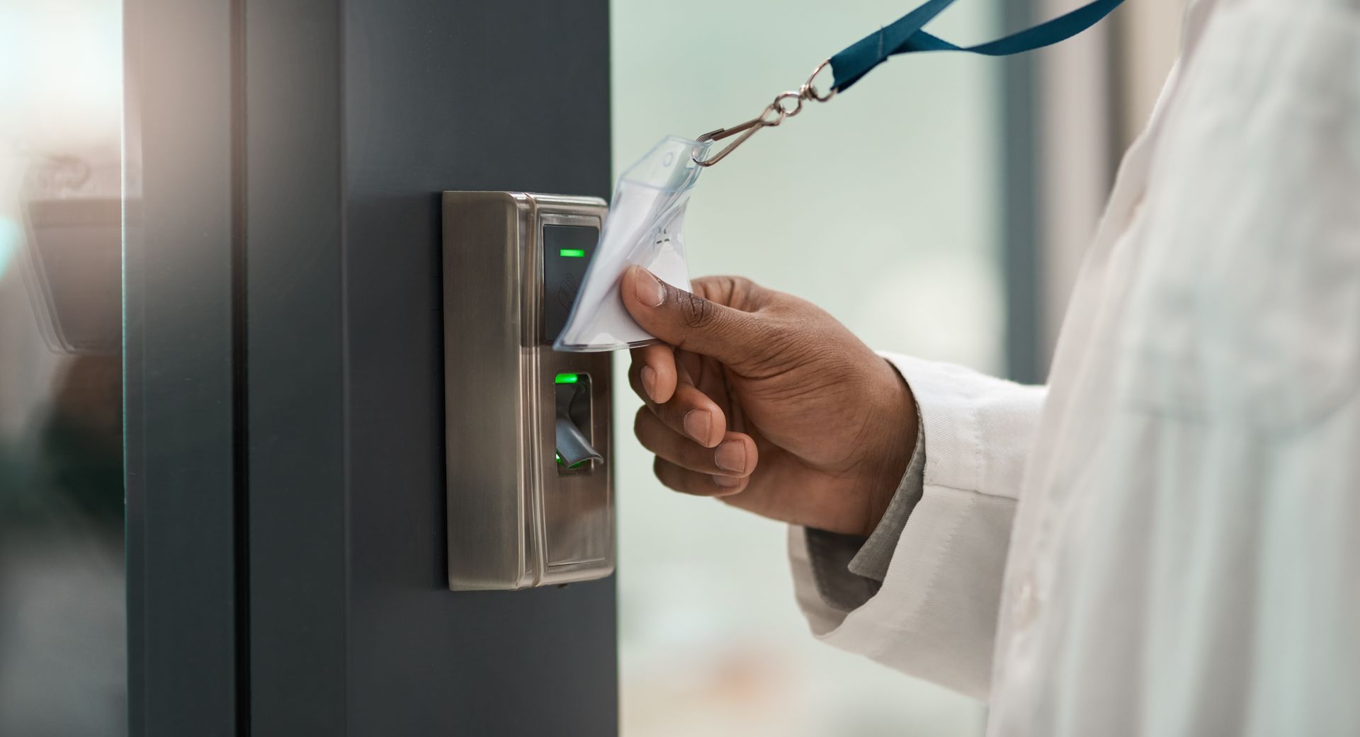 person using an ID badge with a lanyard to access a scanner mounted on a wall person using an ID badge with a lanyard to access a scanner mounted on a wall