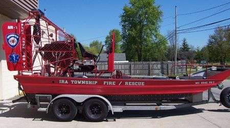 A red boat on a trailer that says Ira Township Fire Rescue.
