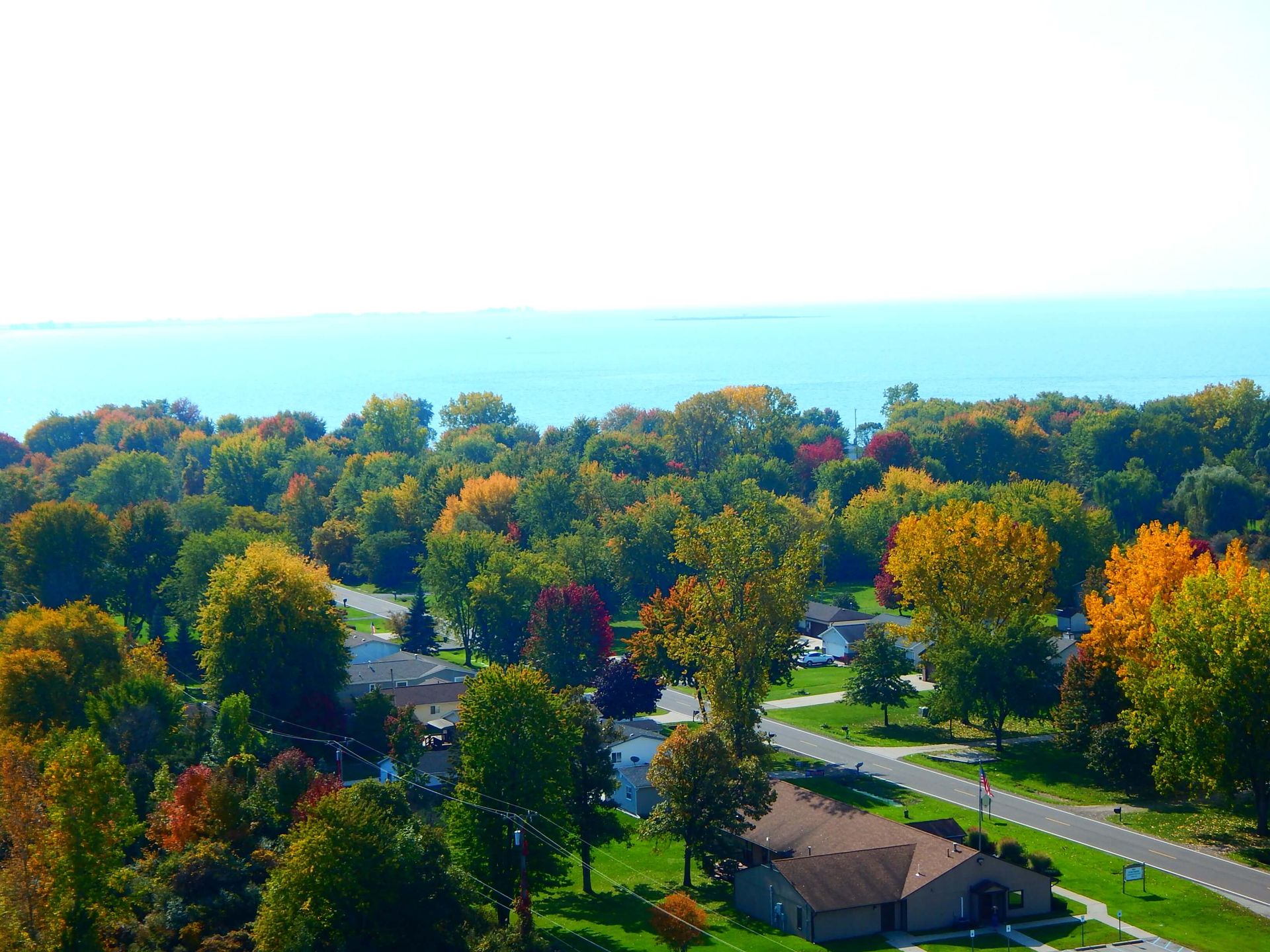 An aerial view of a residential area with a lake in the background.