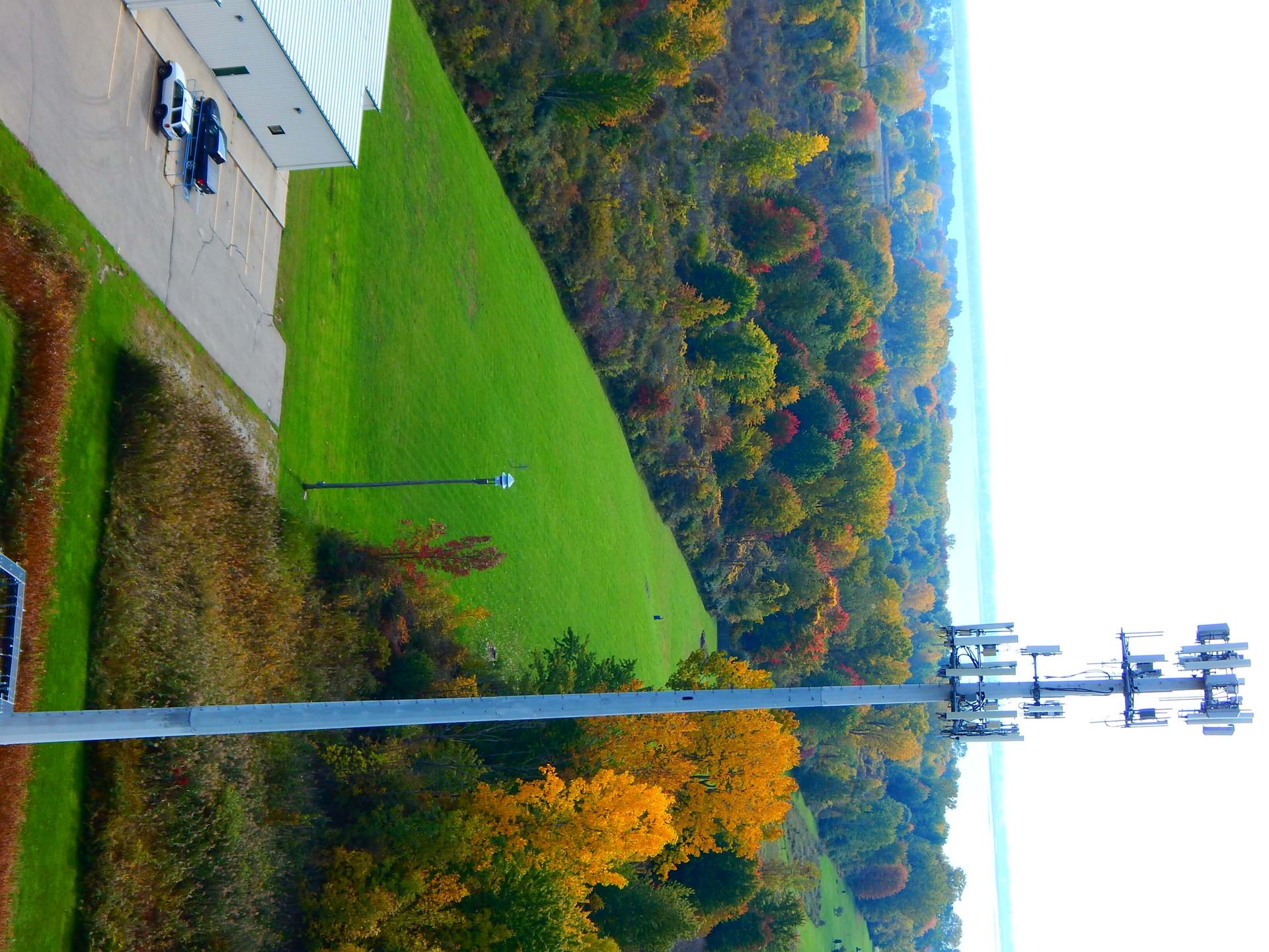 An aerial view of a lush green field with trees in the background.