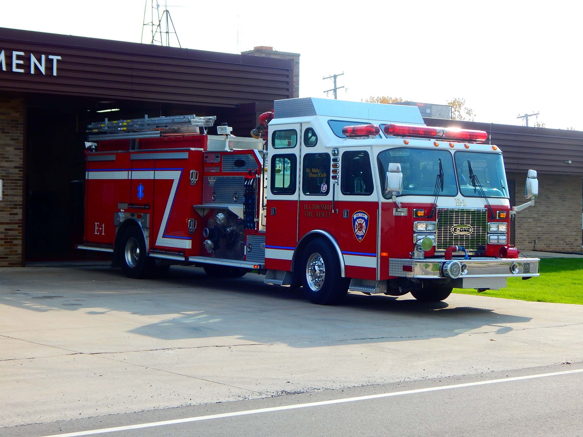 A red fire truck is parked in front of a building that says Ira Township Fire Department.