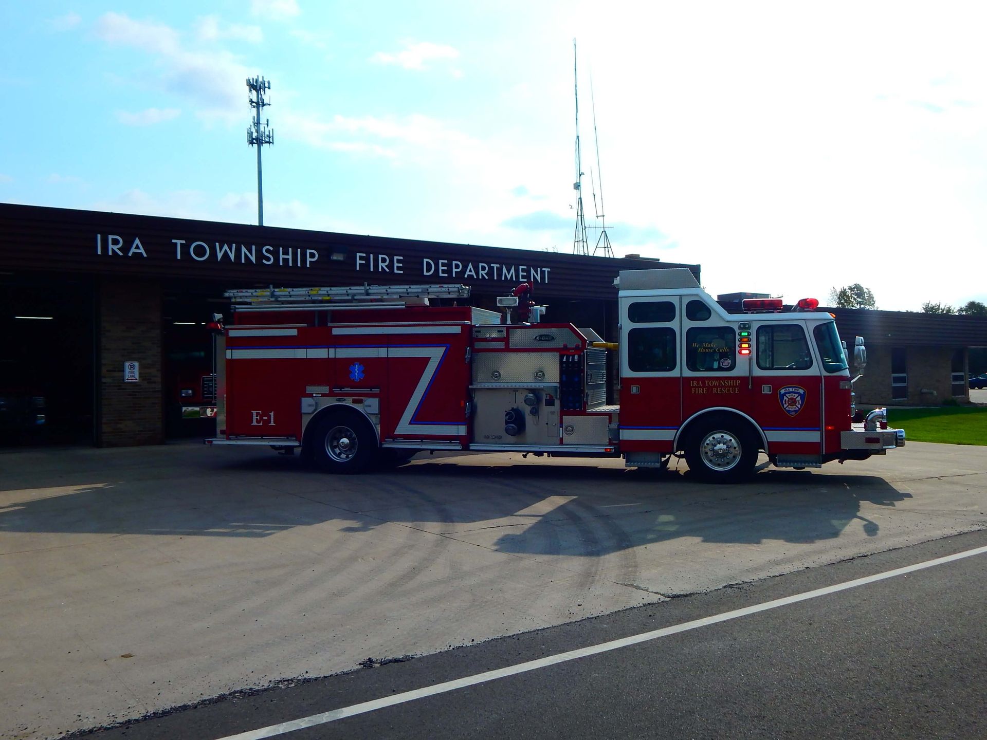 A red fire truck is parked in front of the Ira Township Fire Department.