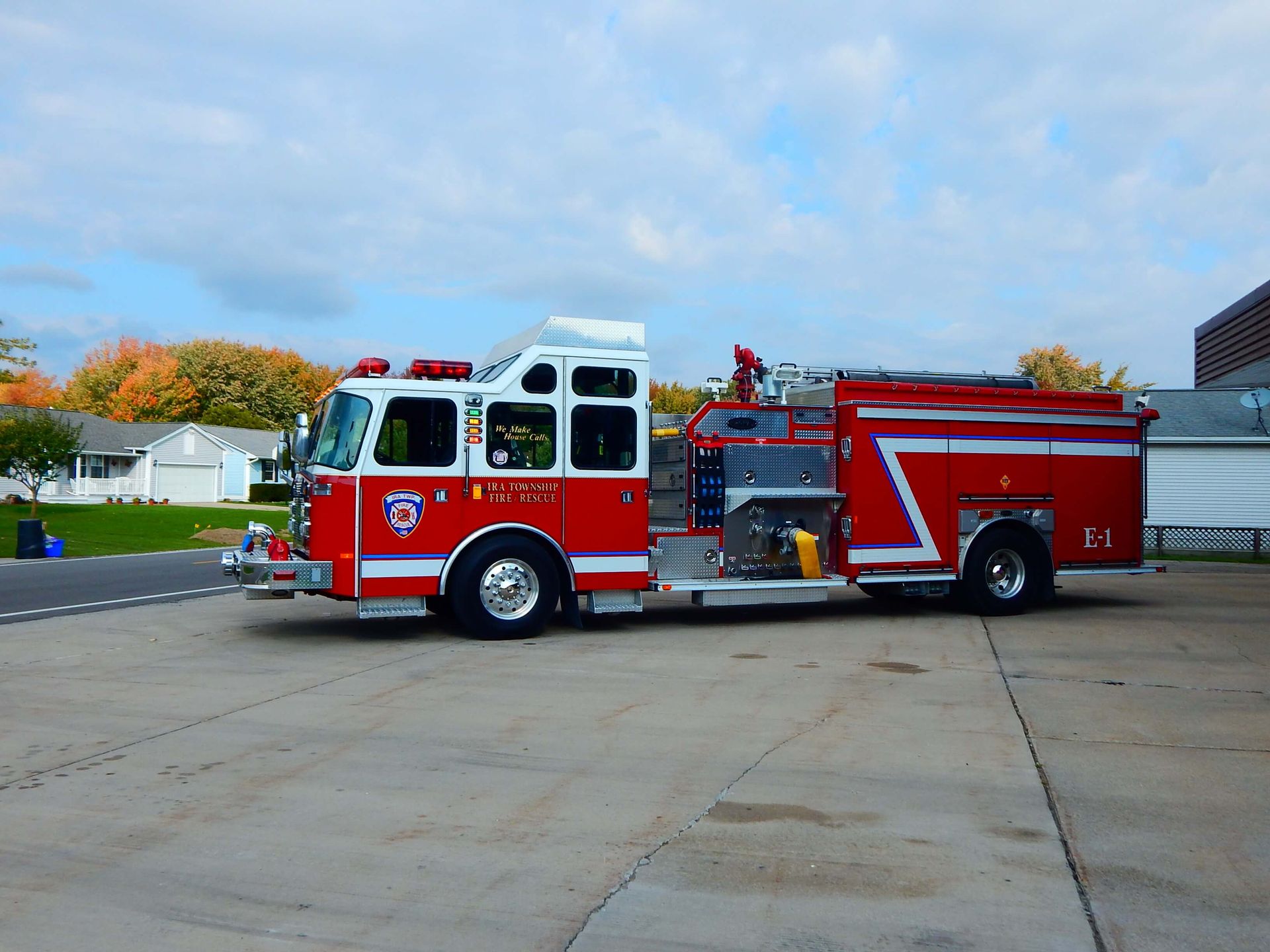 A red fire truck is parked in front of a building that says Ira Township Fire Department.