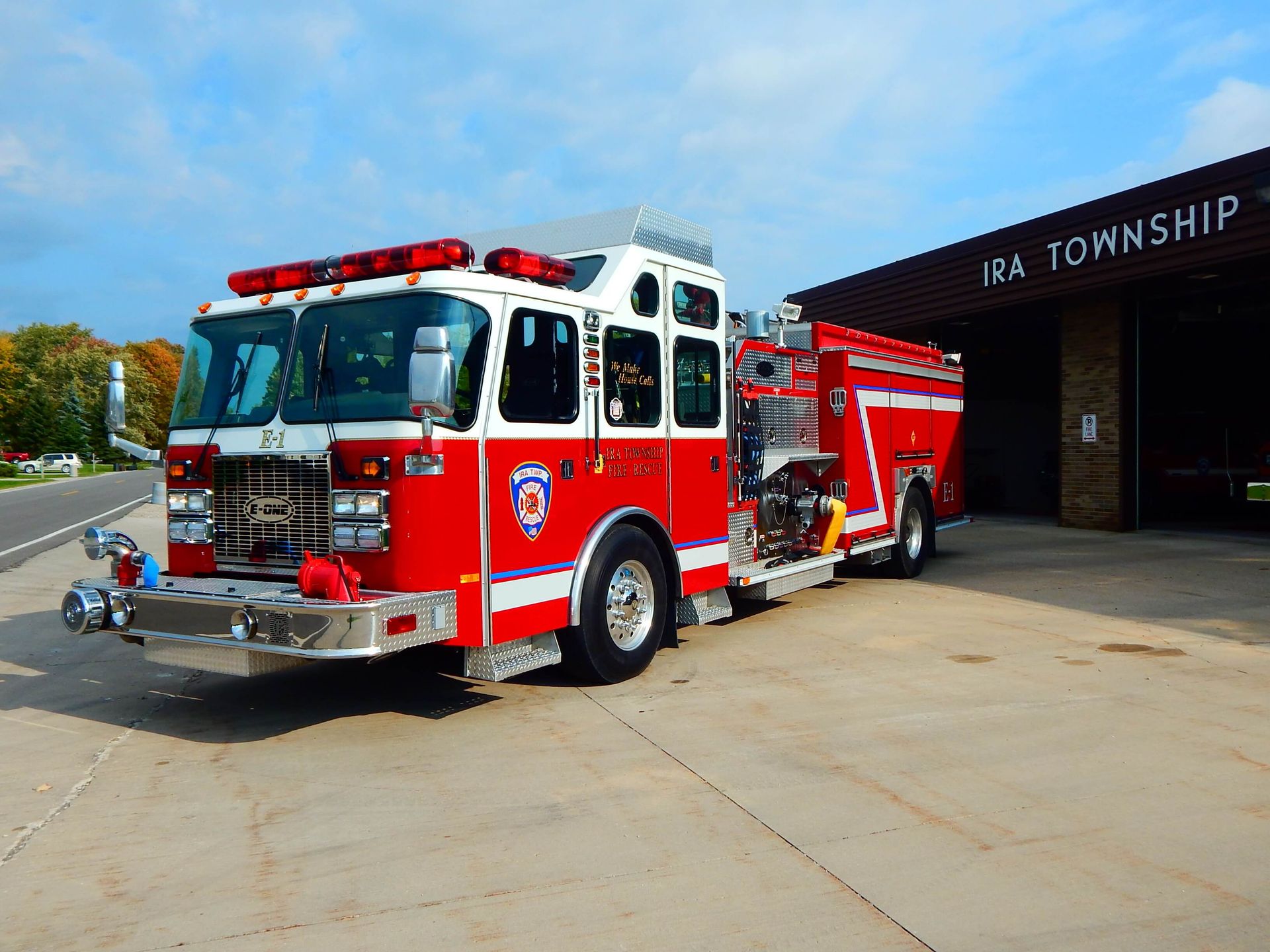 A red and white fire truck is parked in front of Ira Township.