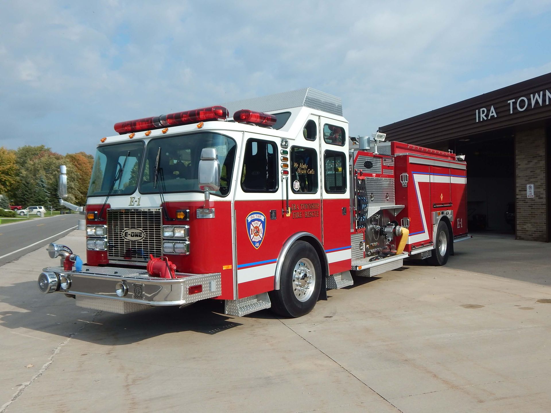 A red fire truck is parked in front of a building that says Ira Township Fire Department.