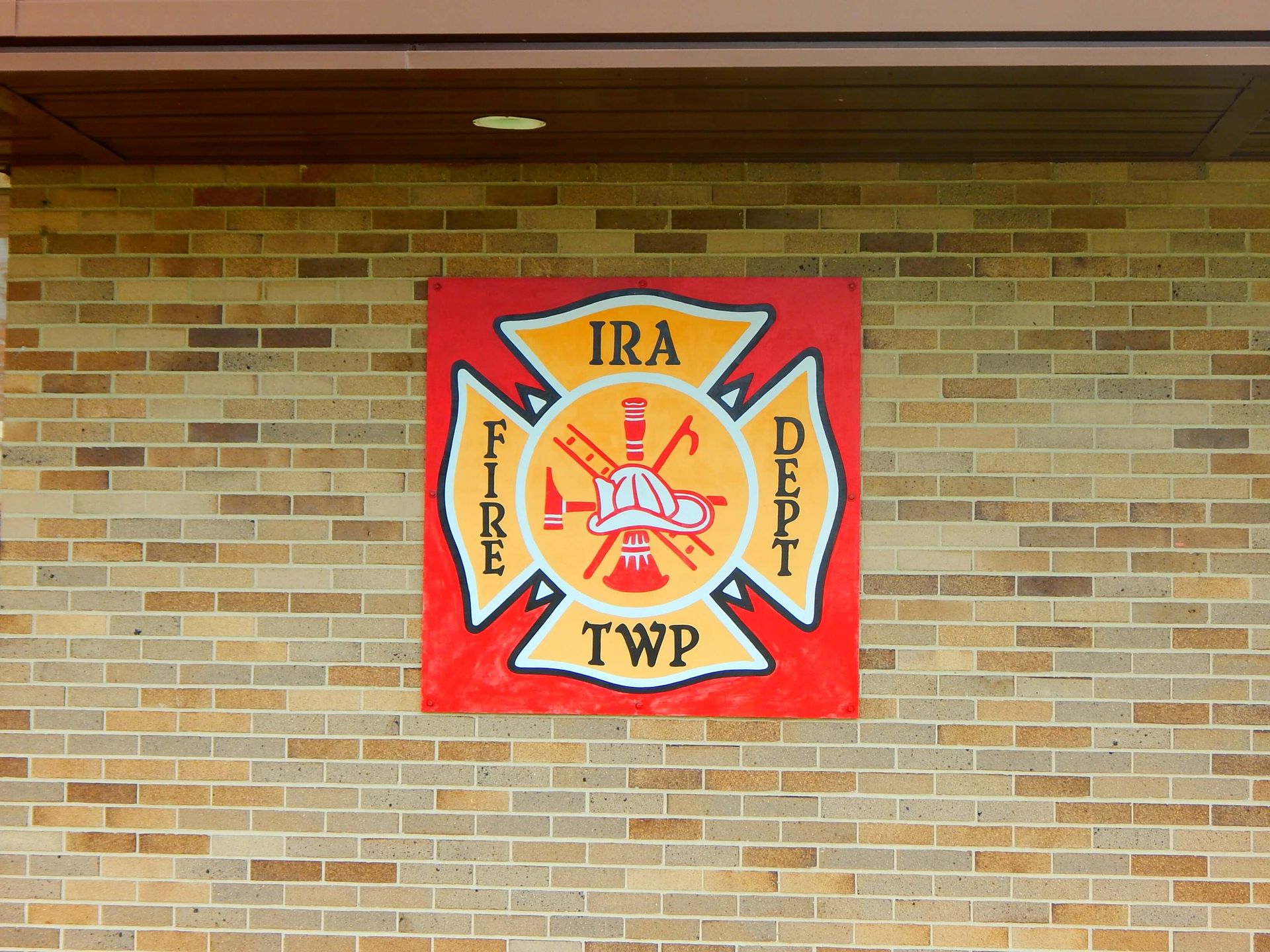A sign on a brick wall says Ira Township Fire Department.