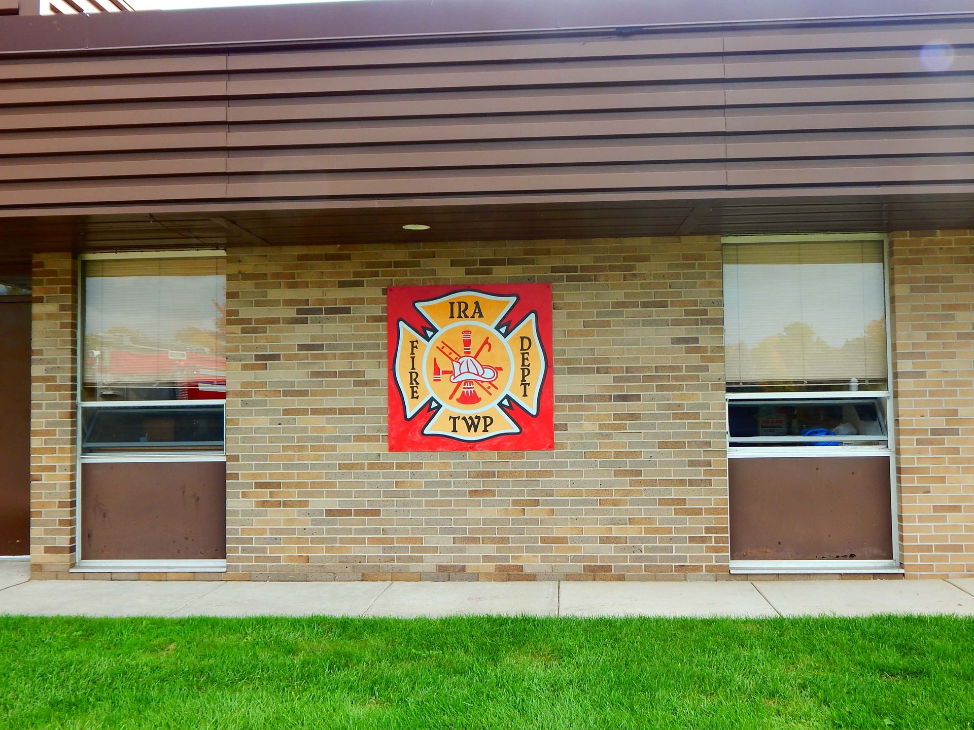 A brick building with a sign on it that says Ira Township Fire Department.
