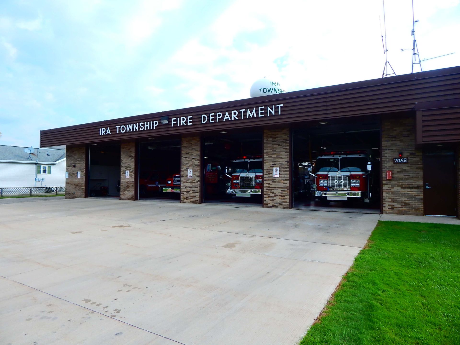 Four fire trucks are parked in front of a fire department building.