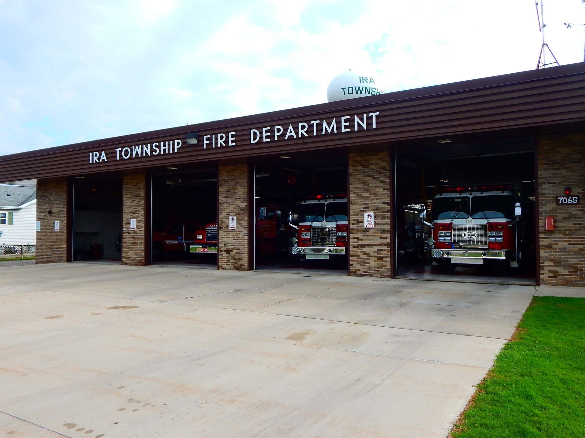 A fire department building with four fire trucks parked inside.