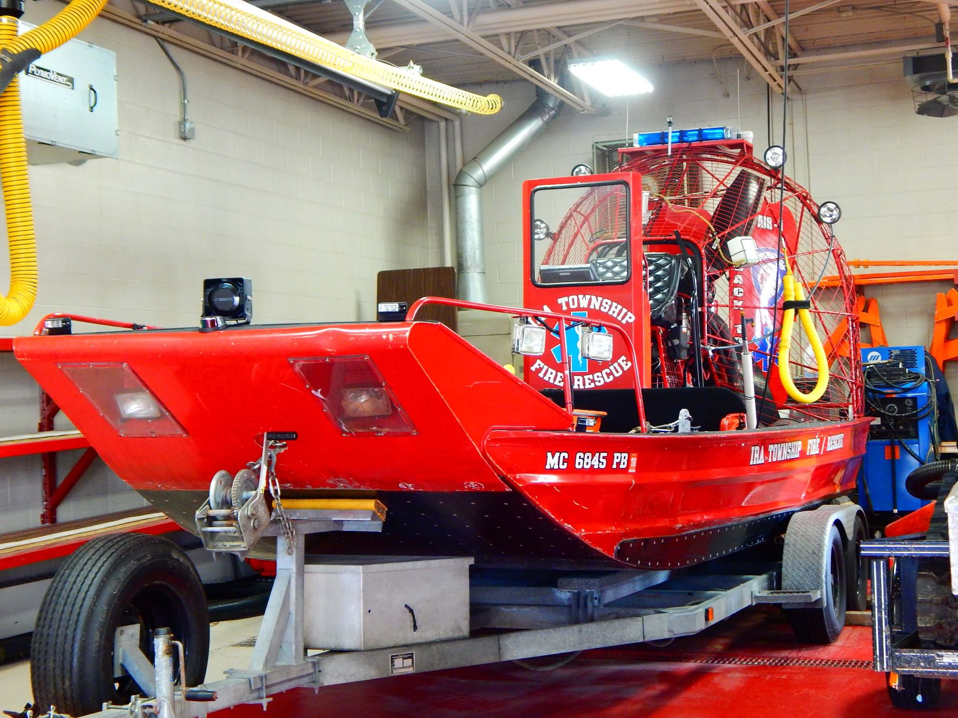 A red boat on a trailer with Ira Township Fire Rescue written on the side.