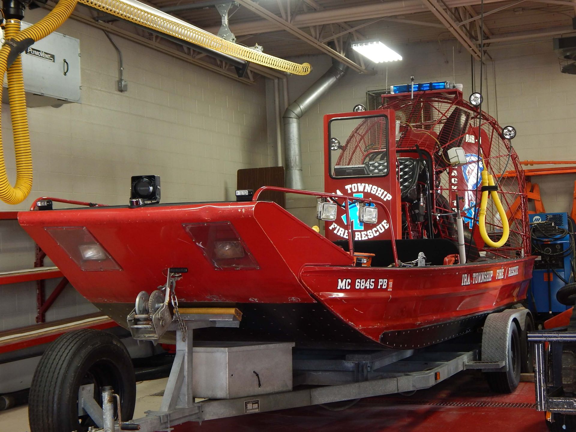 A red boat on a trailer with Ira Township Fire Rescue written on the side.