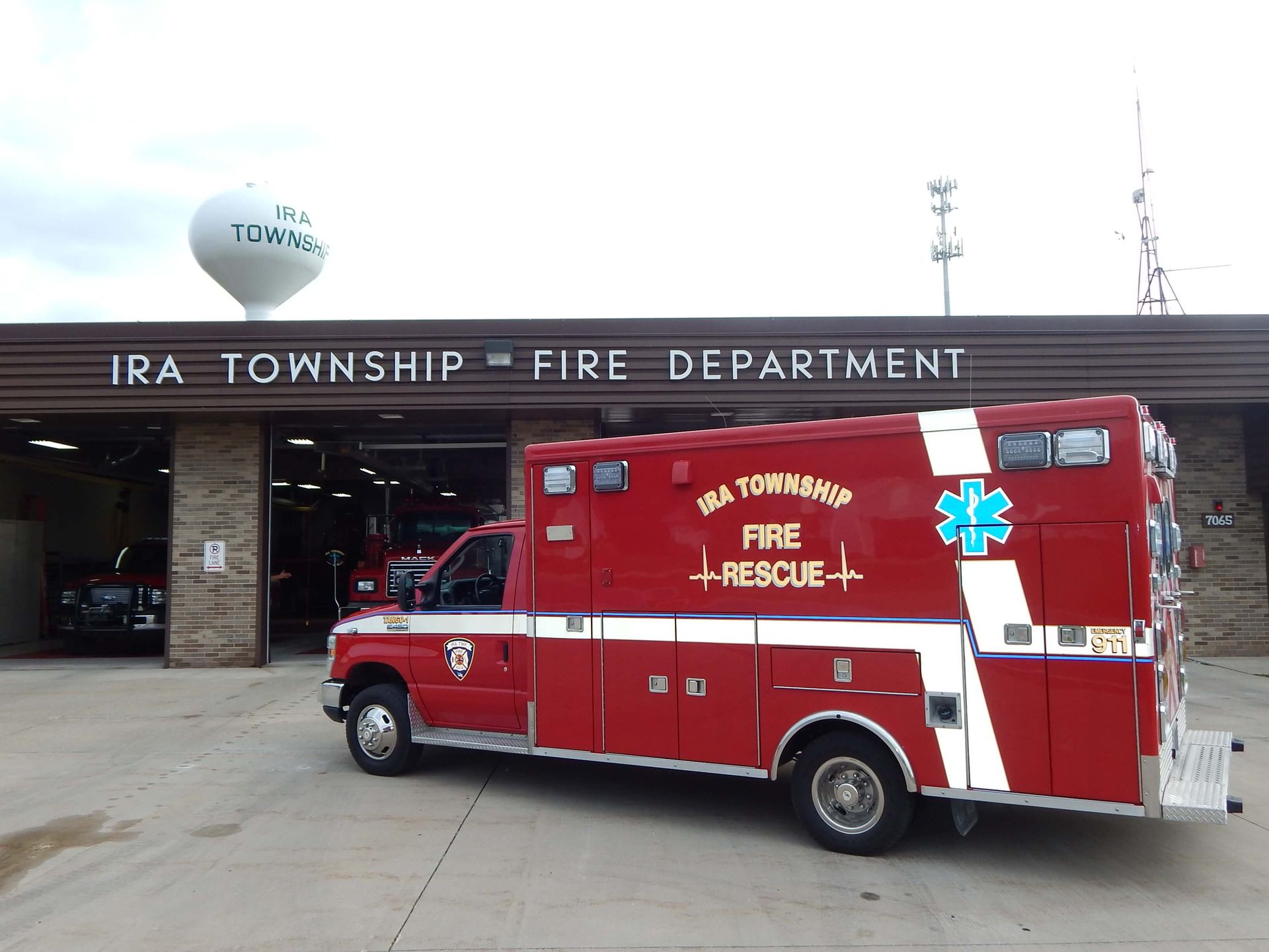 A red fire truck is parked in front of the Ira Township Fire Department.