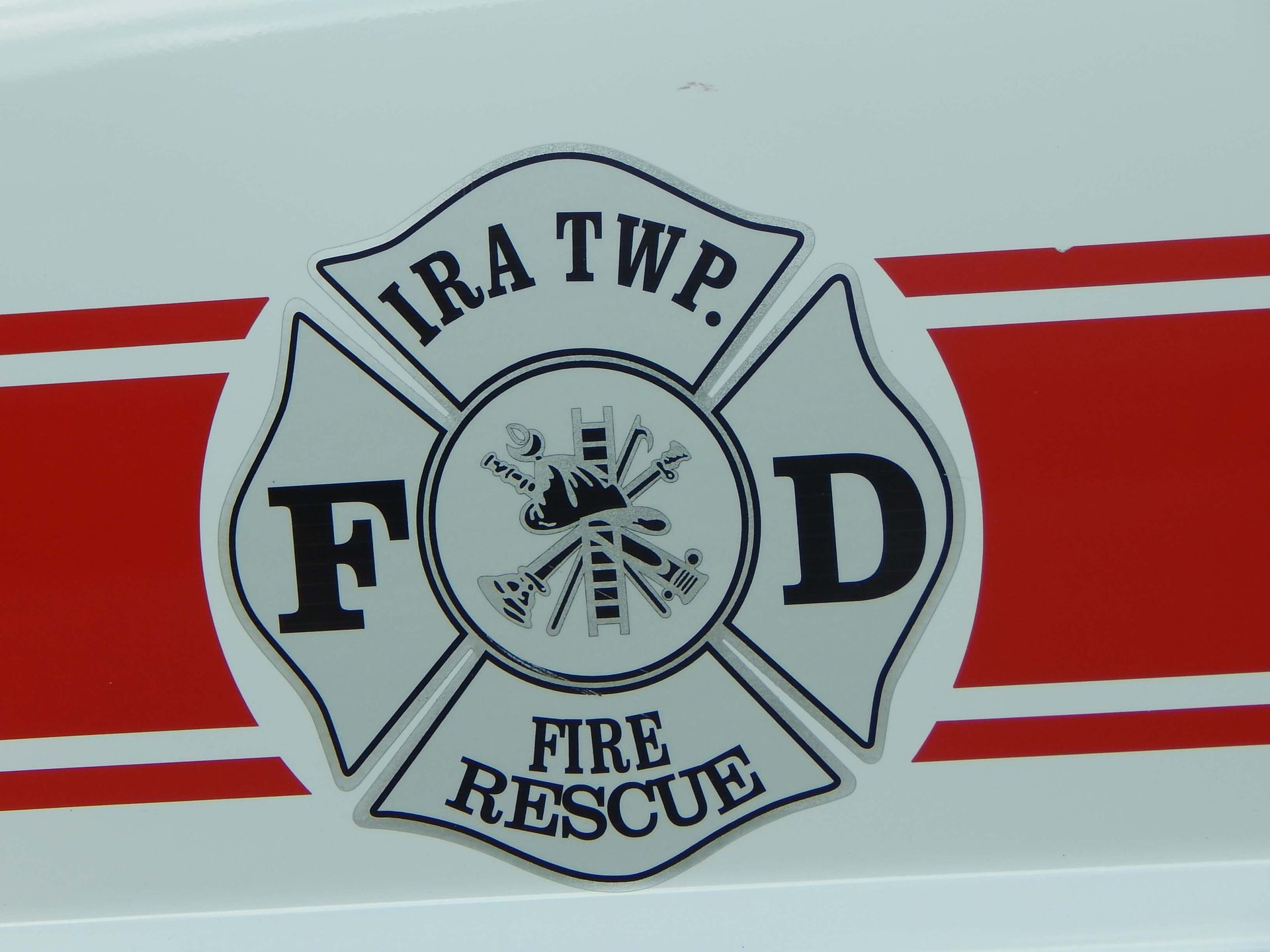 Ira Township Fire Rescue logo on a red and white striped background.