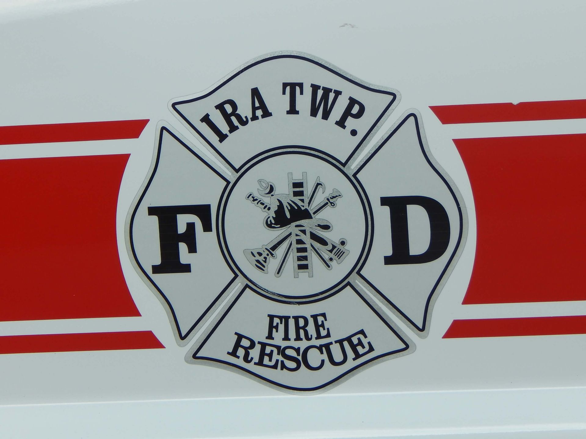 Ira Township Fire Rescue logo on a red and white striped background.