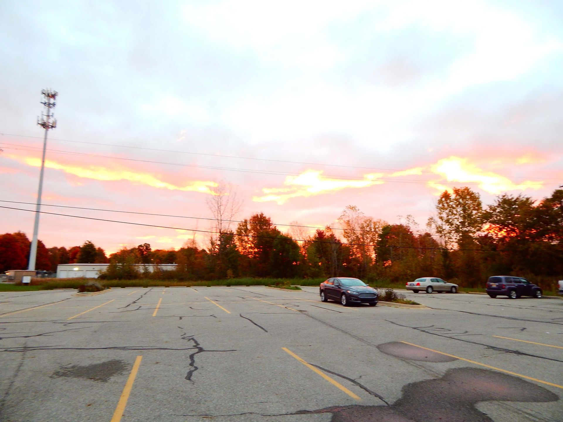 A parking lot with a sunset in the background.