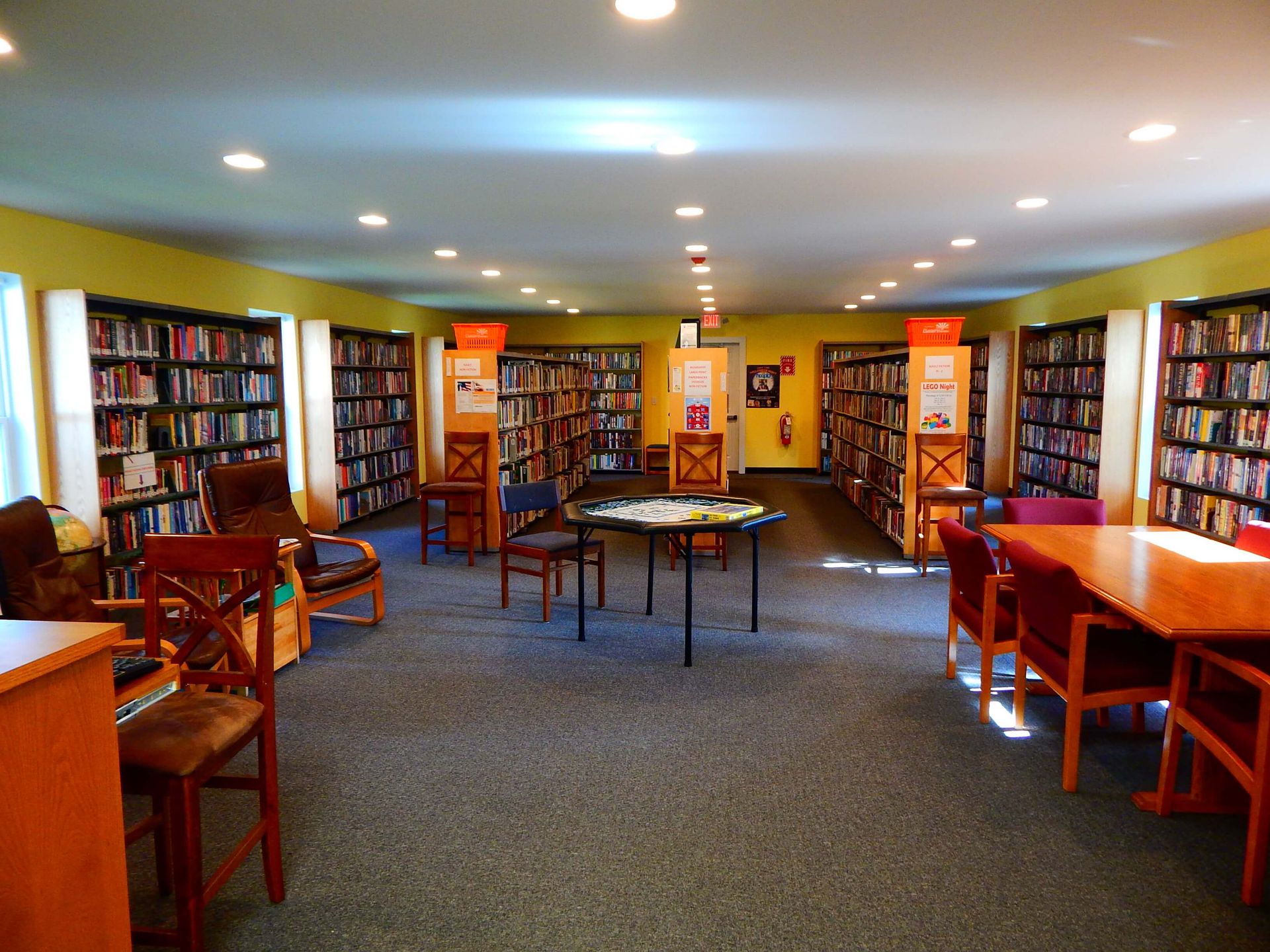 A library filled with lots of books and chairs.
