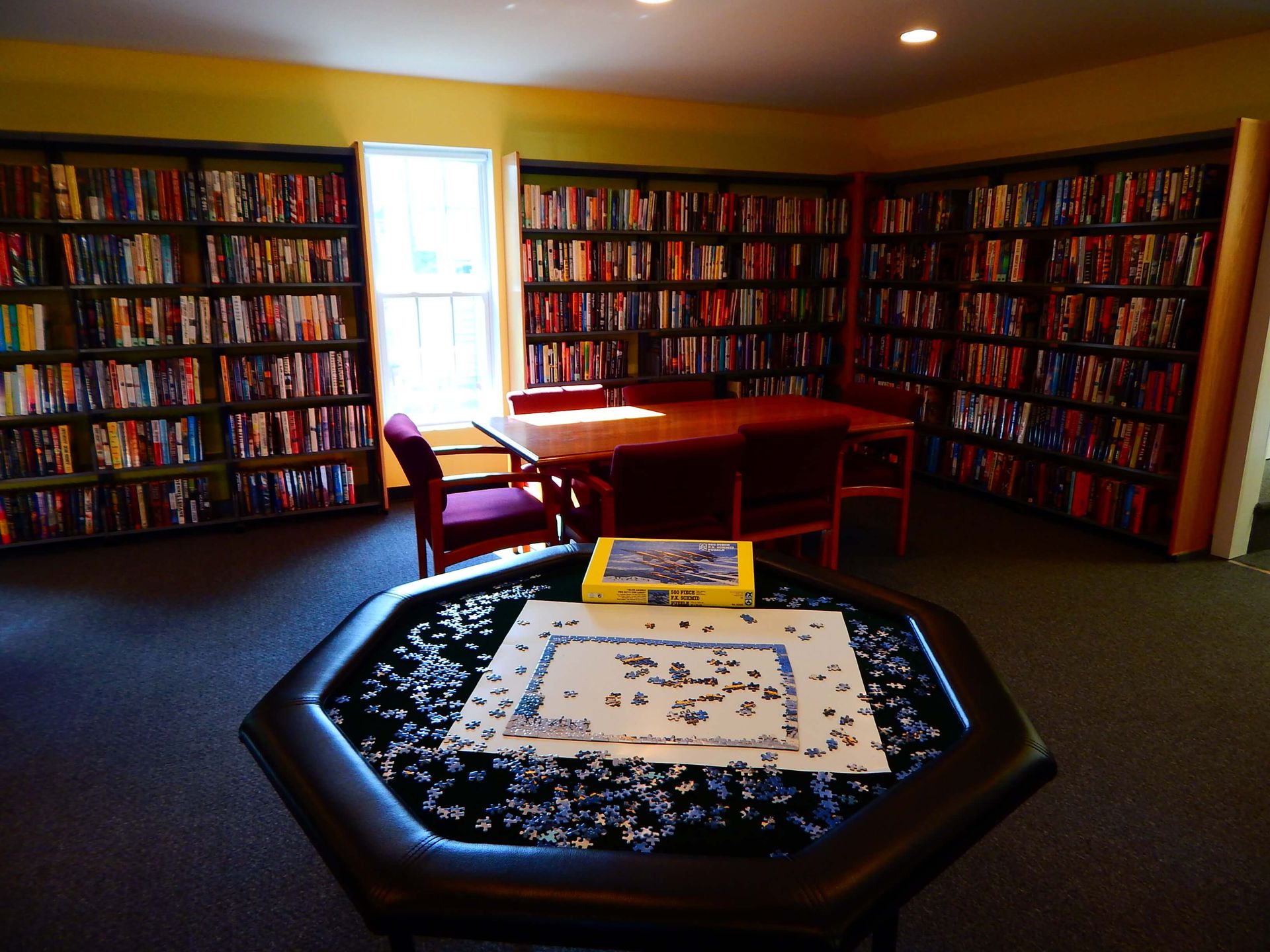 A table with a puzzle on it in a library.