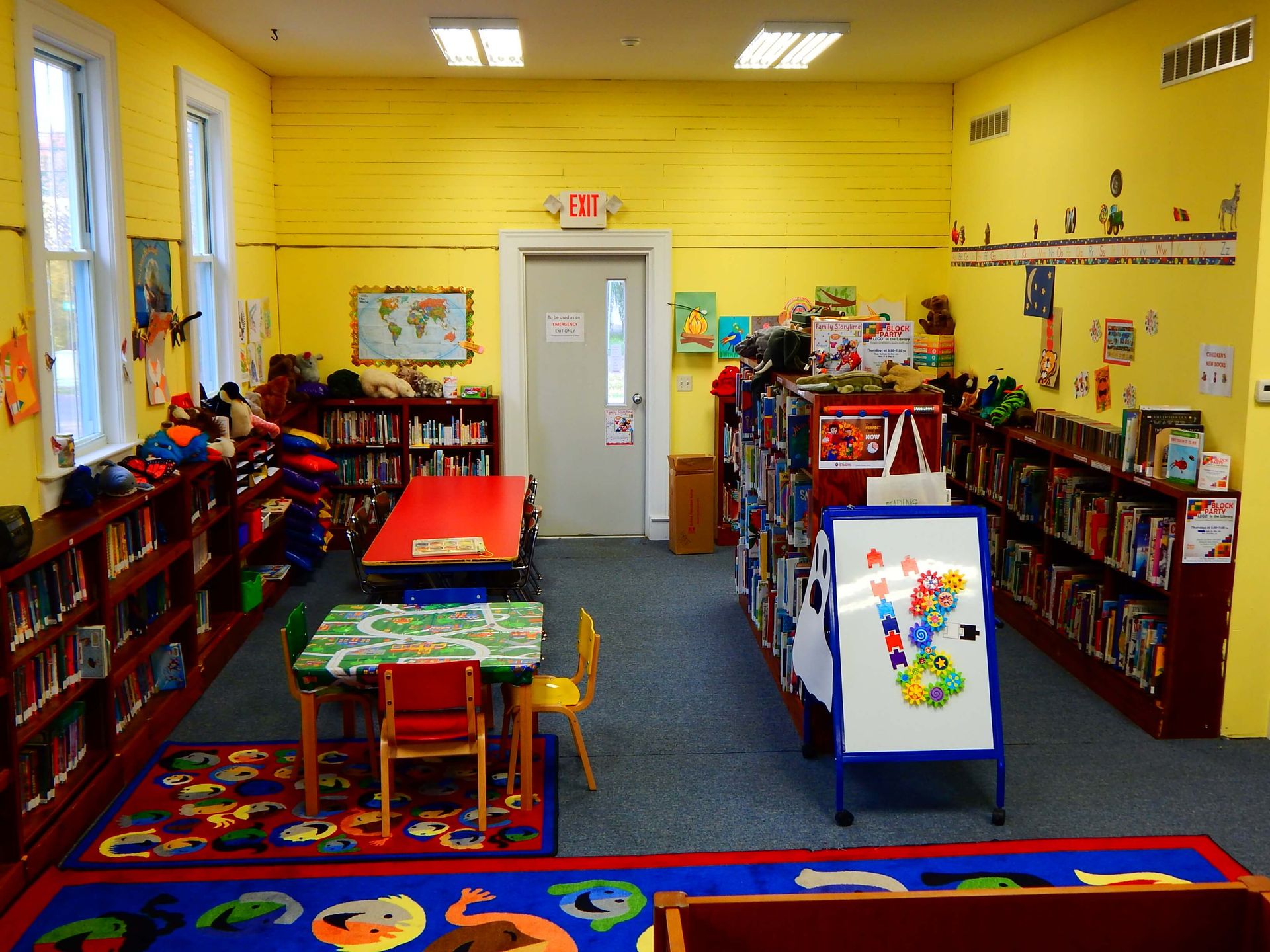A children's library with an exit sign on the door.