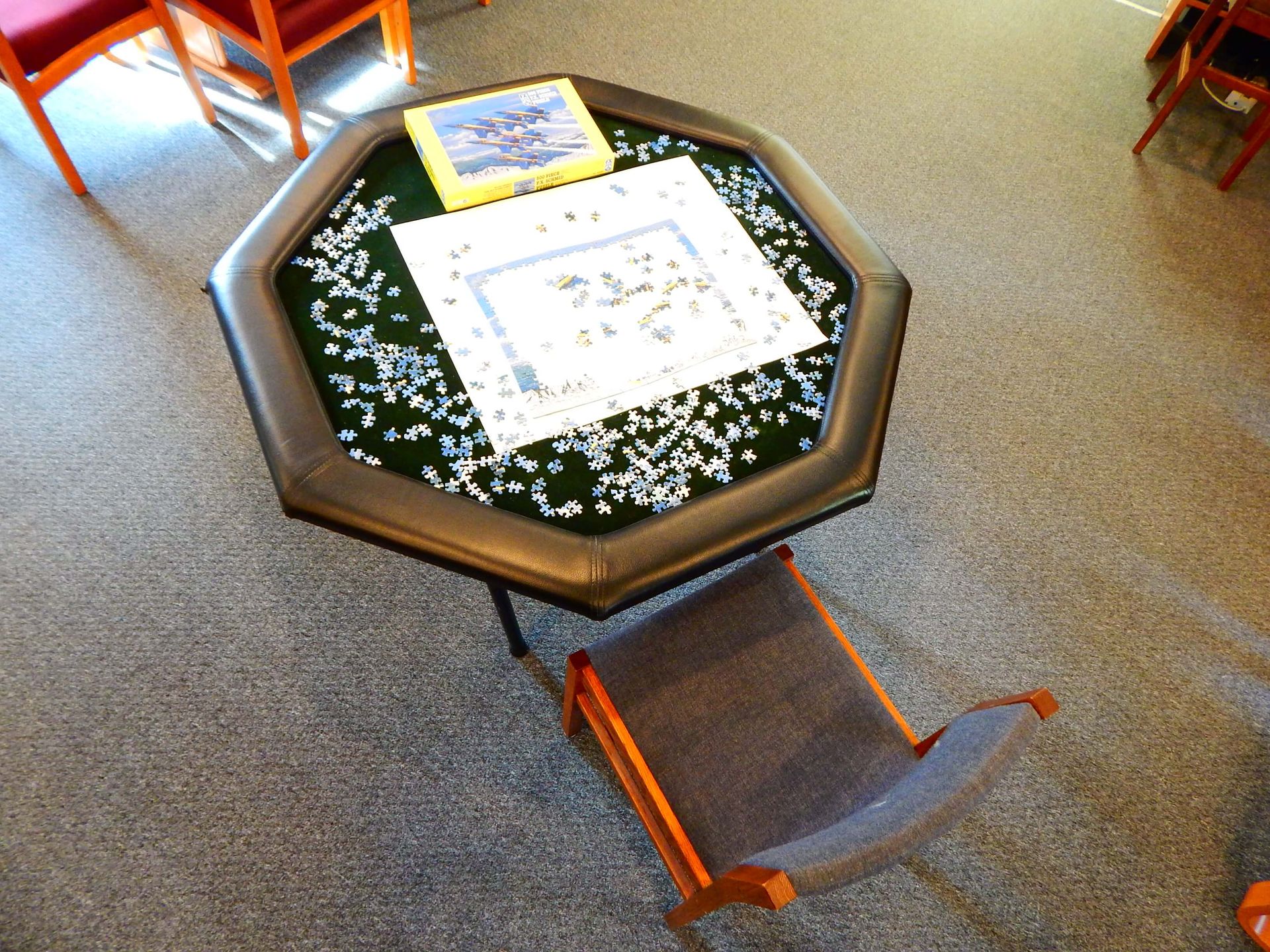 A table with puzzle pieces on it and a picture on it.