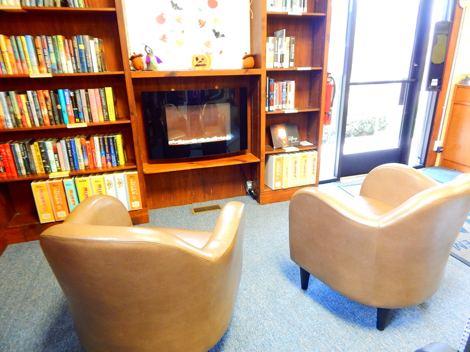 Two chairs in front of a fireplace in a library