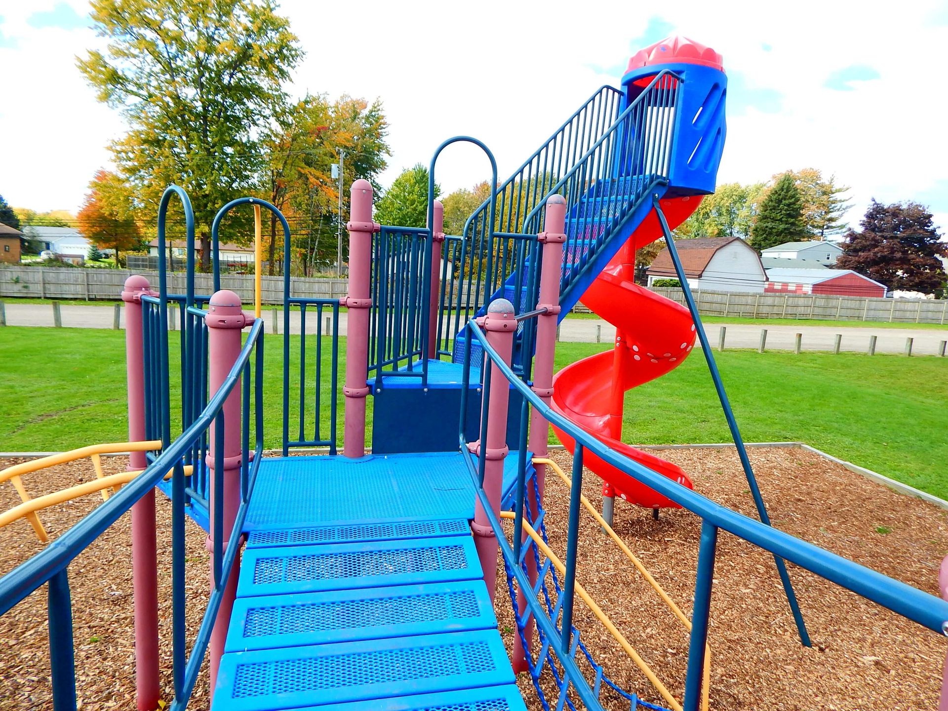 A colorful playground with a red slide and stairs