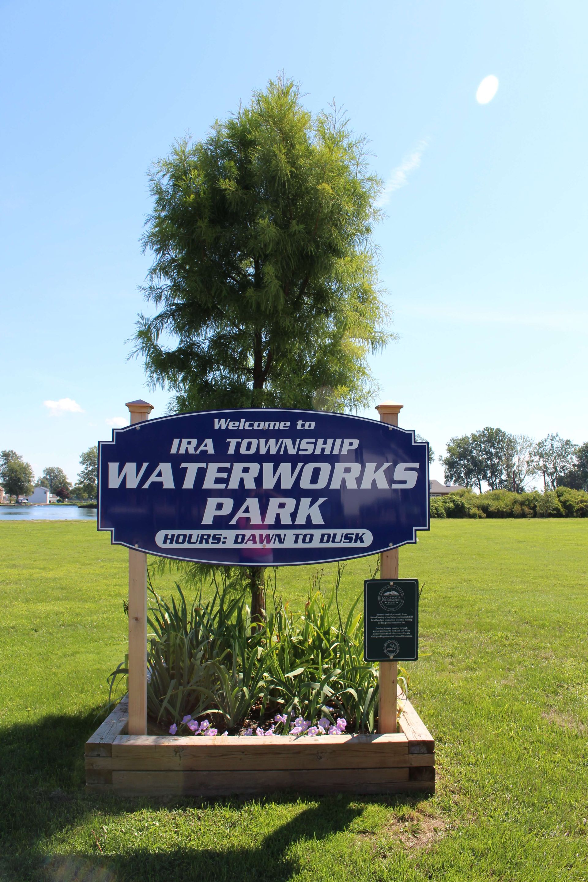 A blue sign that says Ira Township Waterworks Park on it.