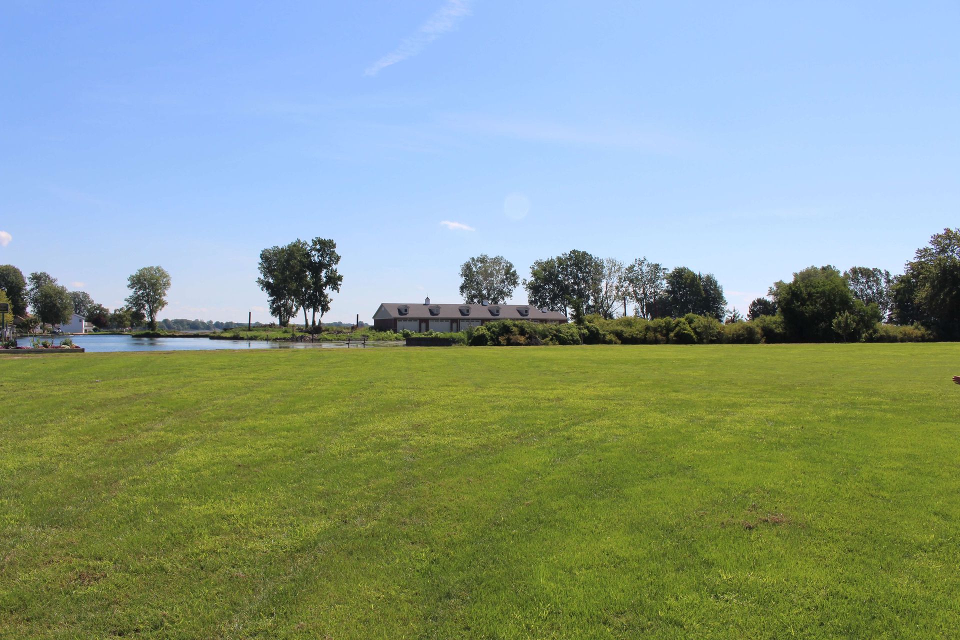 A large grassy field with a house in the background.