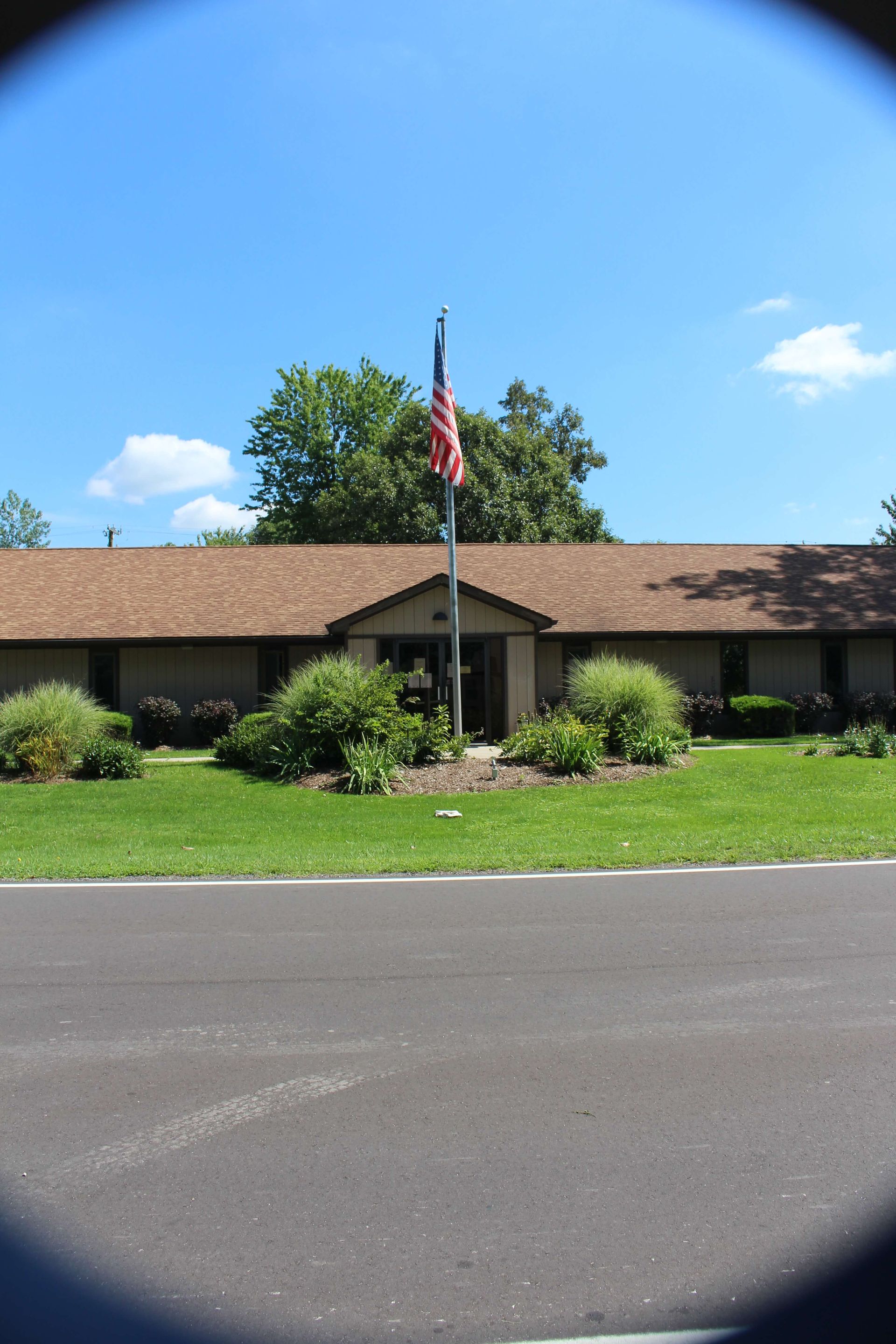 An American flag is flying in front of a house.