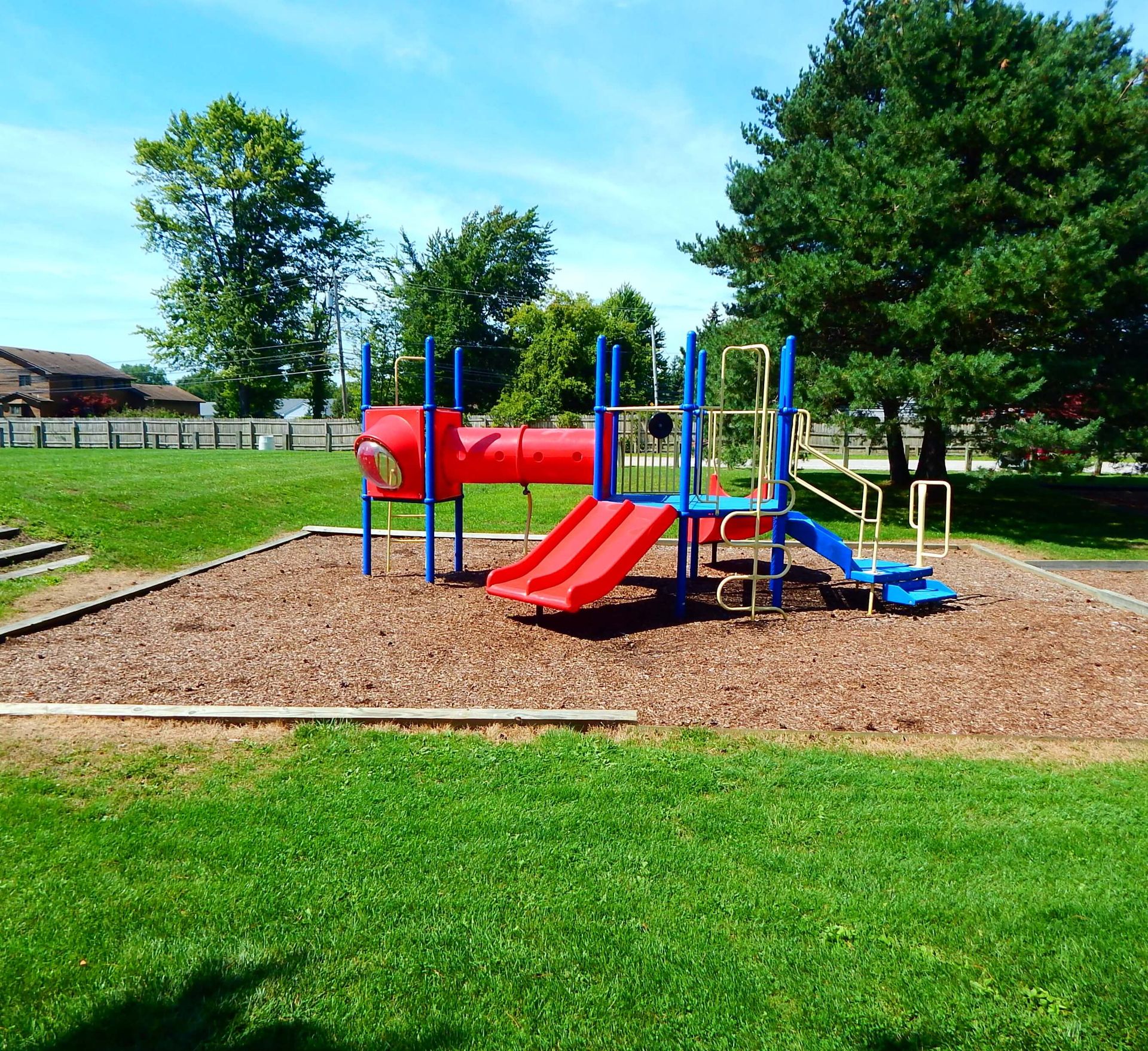 A playground with a red slide and a blue slide.