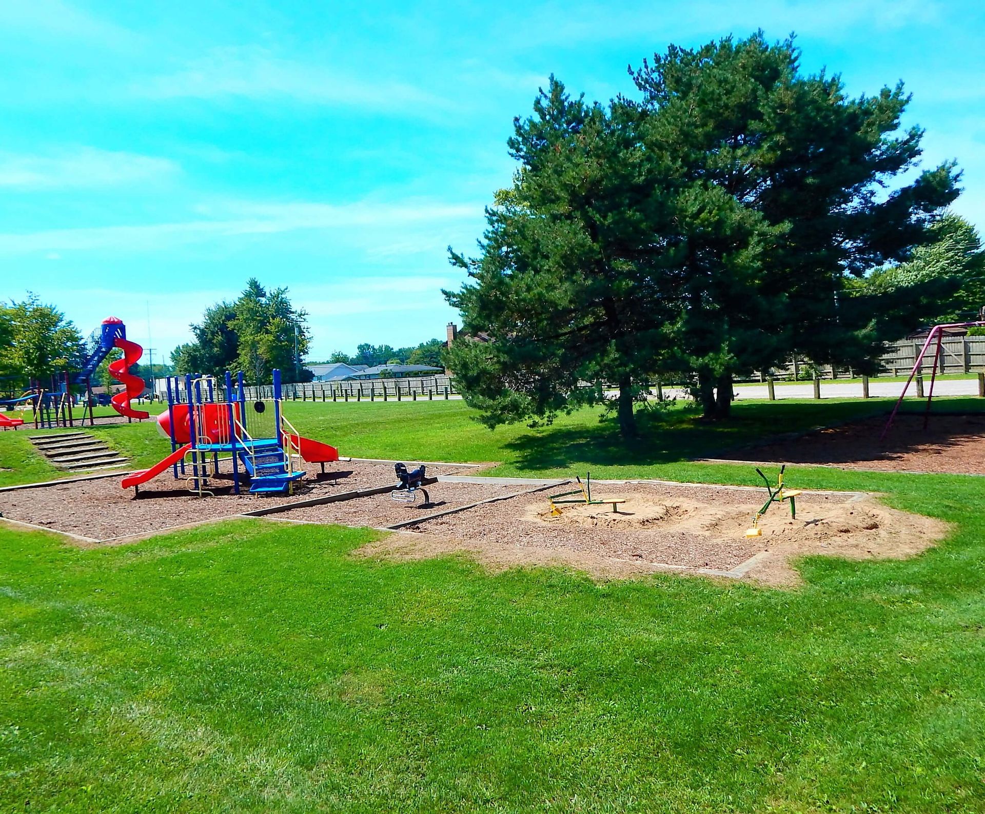 A children's playground in a park on a sunny day.