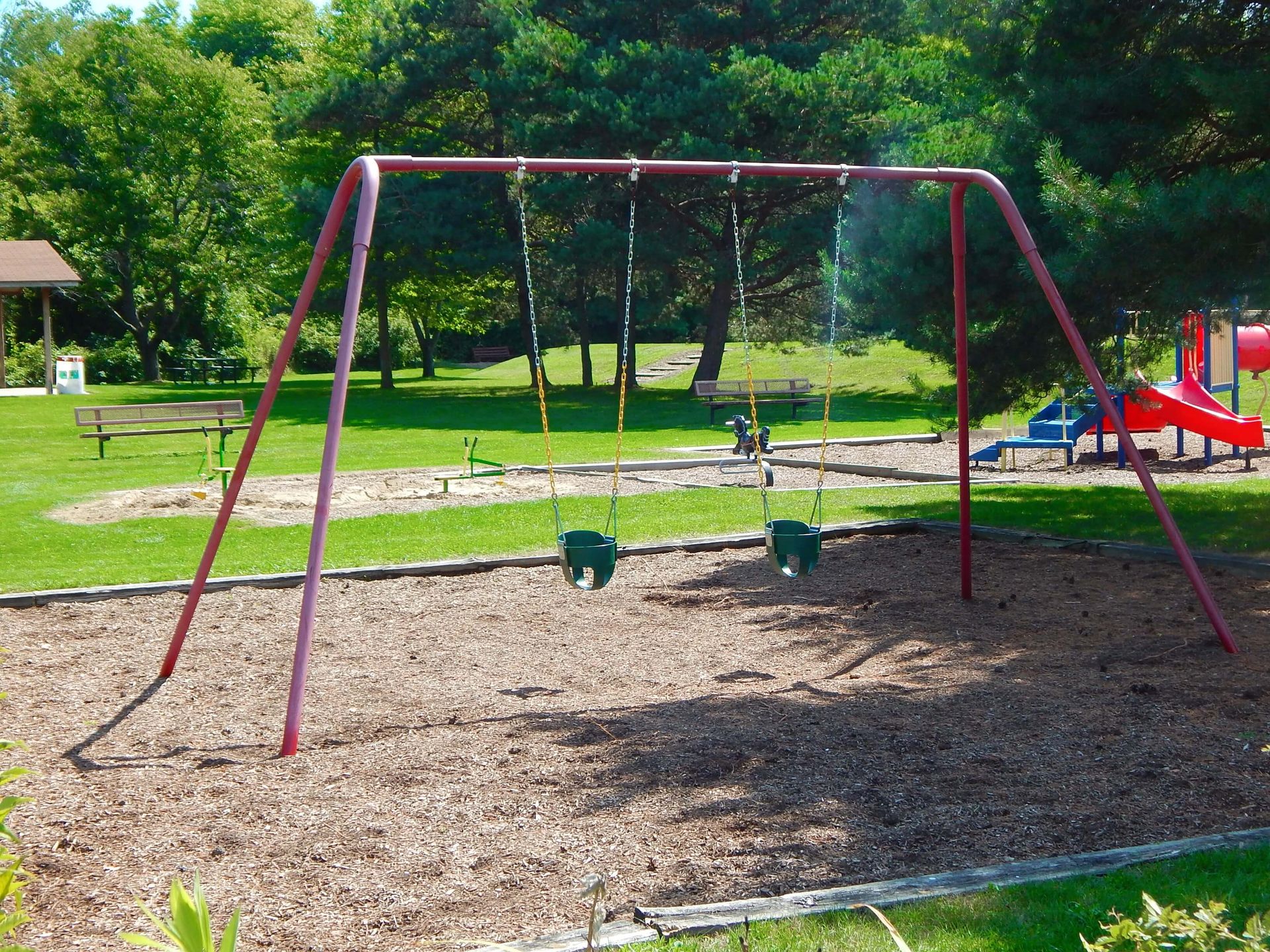 A playground with swings and a slide in the background