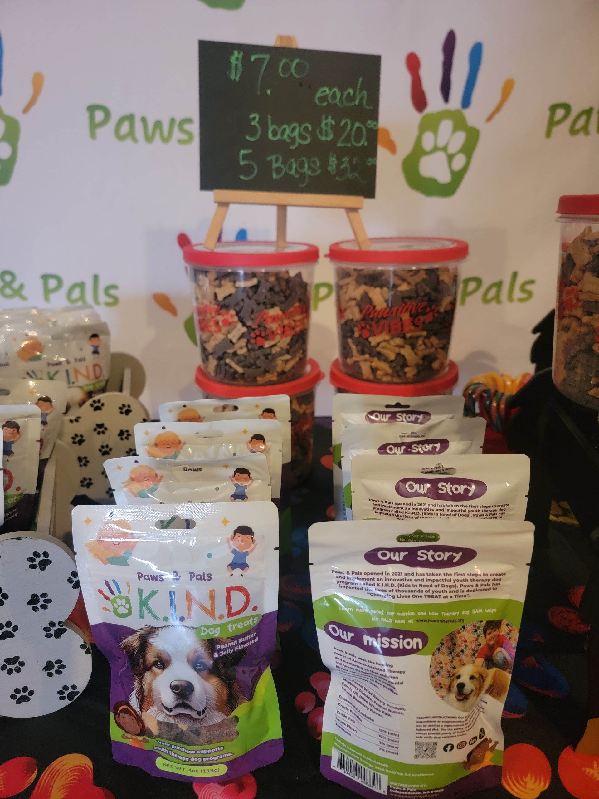 A display of dog treats with a sign that says paws & pals