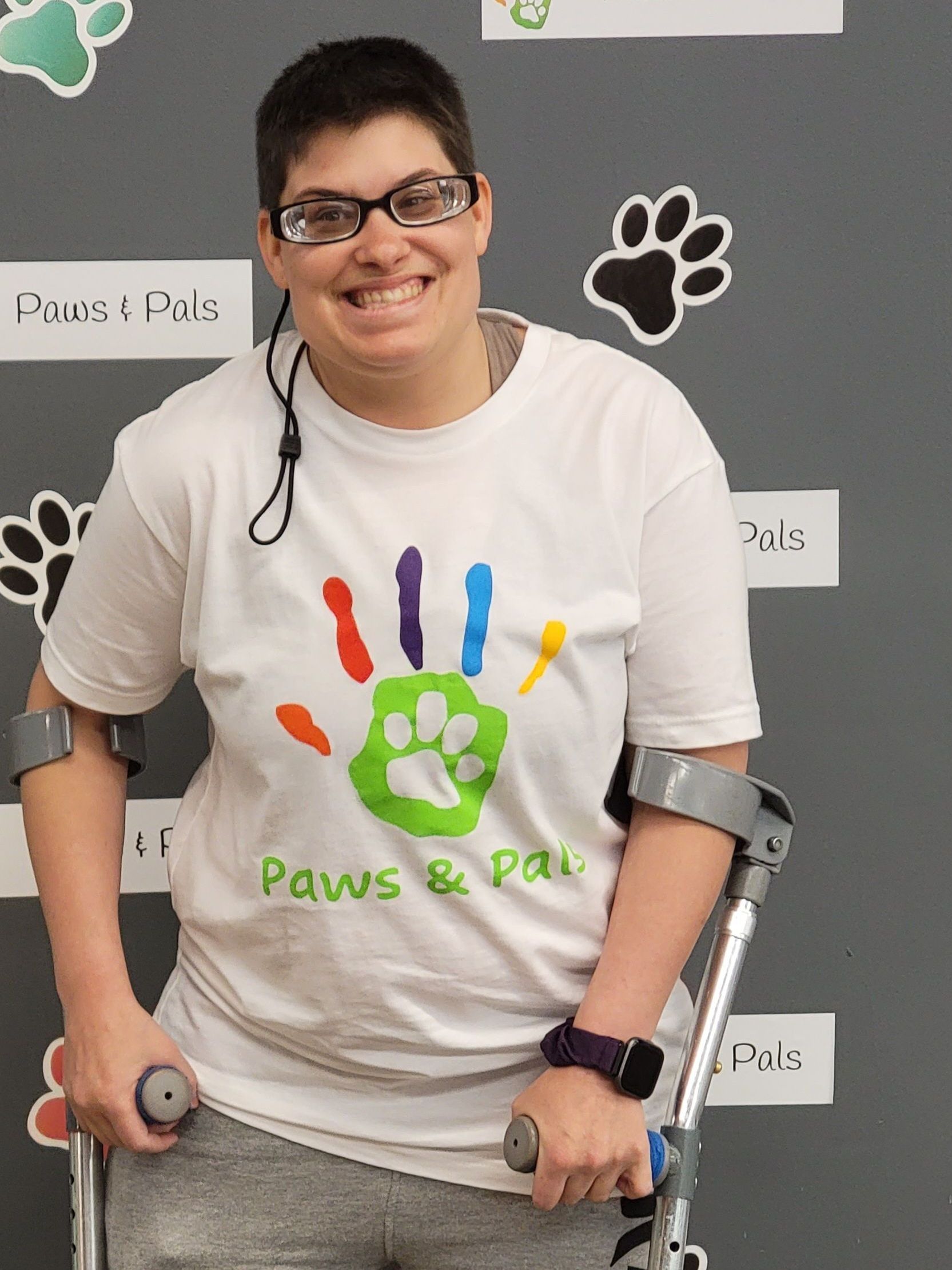 A woman with crutches wearing a paws & paws shirt