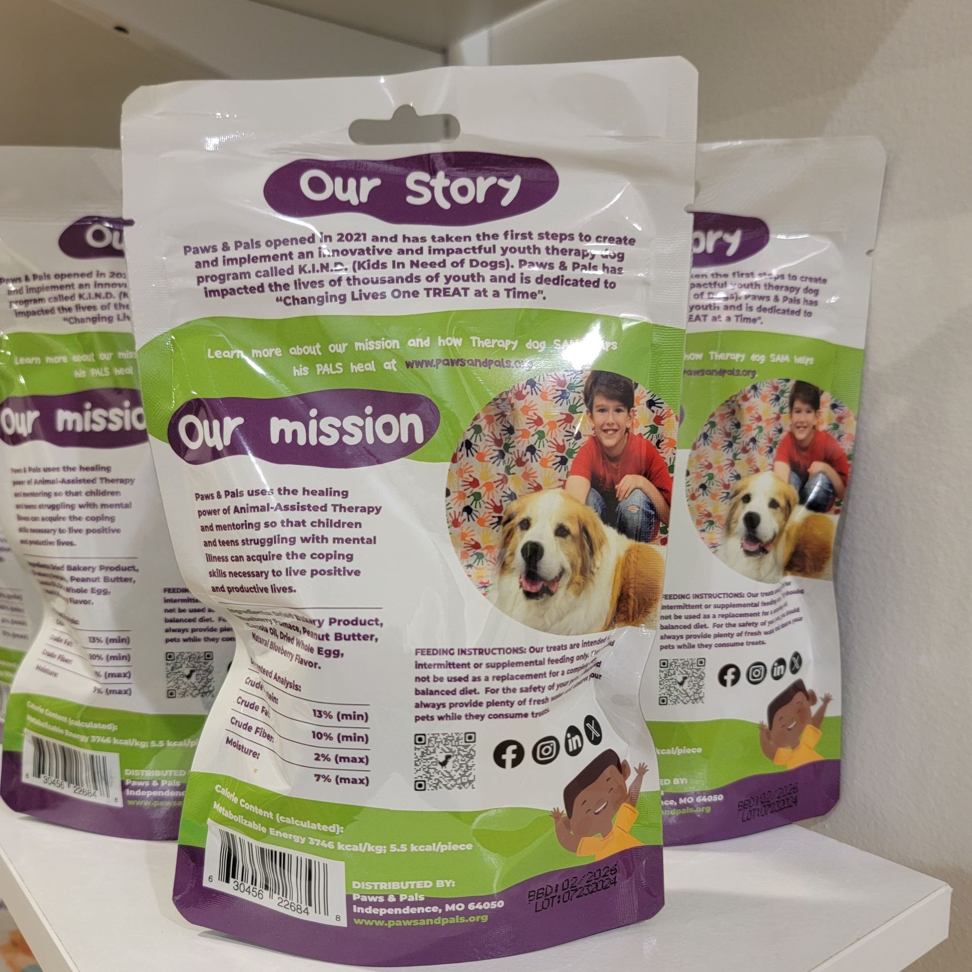 Three bags of our story our mission dog treats on a shelf