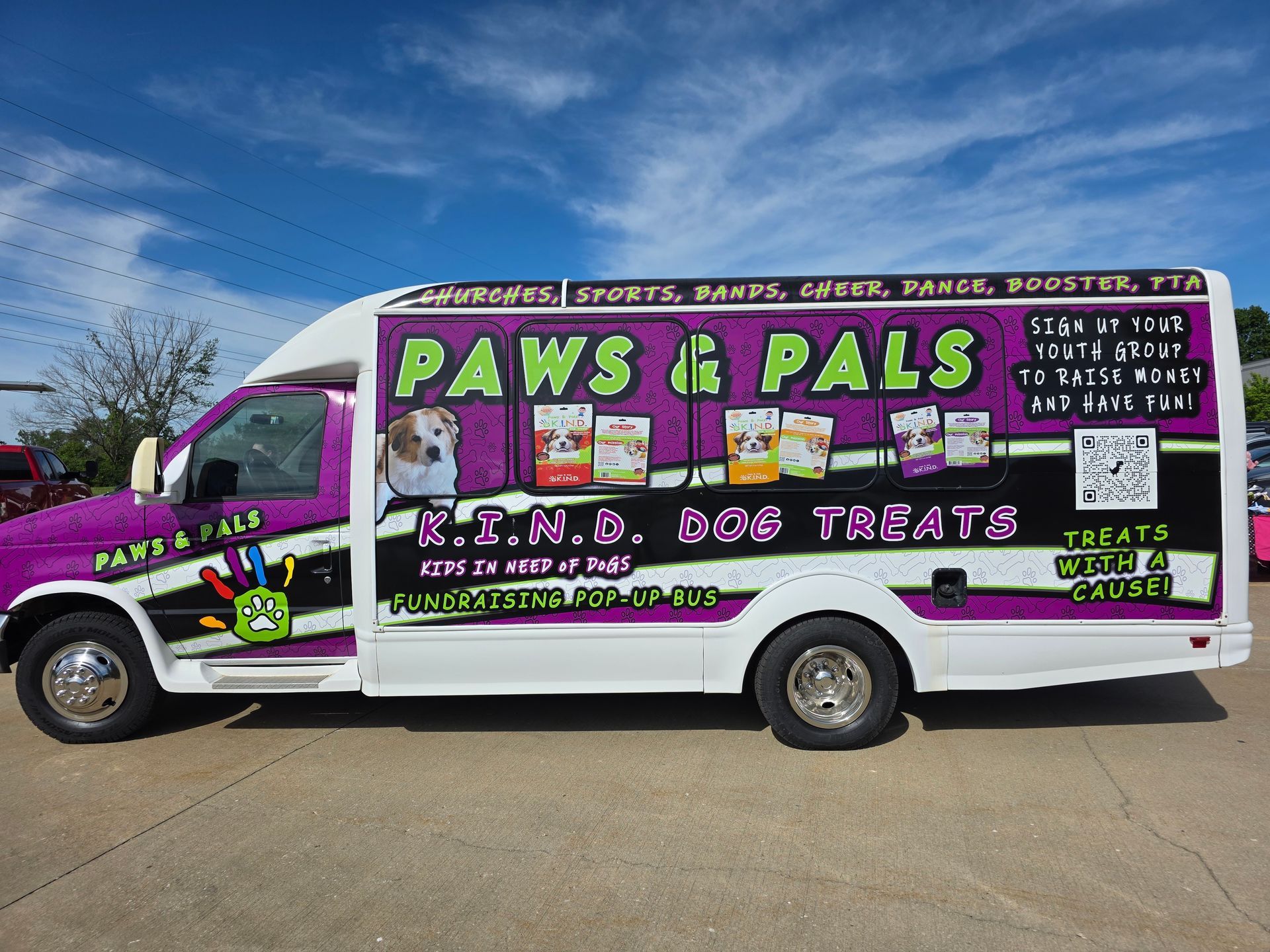 A dog is licking its nose next to a bag of dog treats.