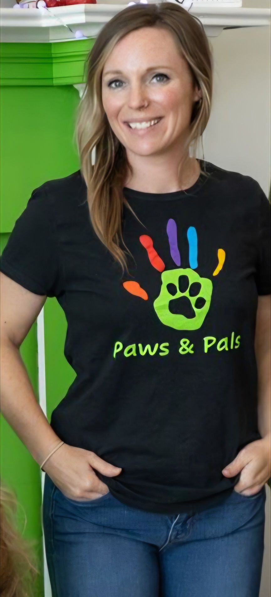 A woman is sitting on a couch wearing a paws and paws shirt